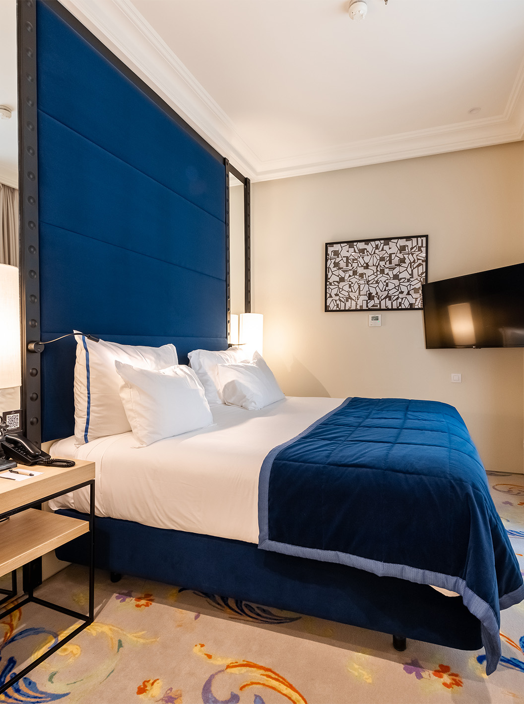 The Suite at Pestana Plaza Mayor Madrid has a double bed, bedside table, TV on the wall and window with curtains