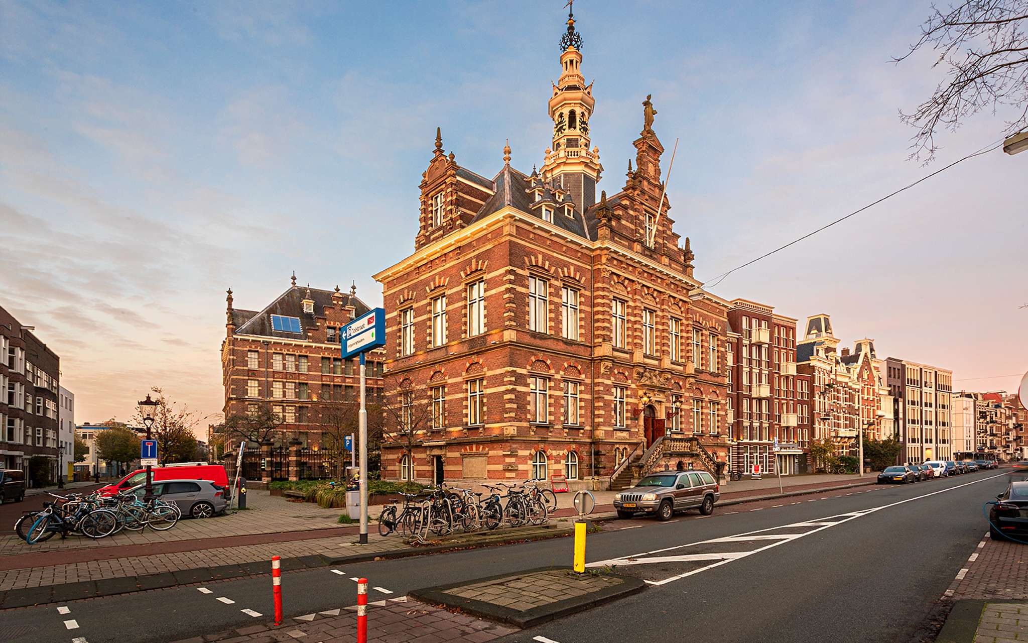 Exterior view of Pestana Amsterdam Riverside, with red bricks, parked bicycles, and a clear sky