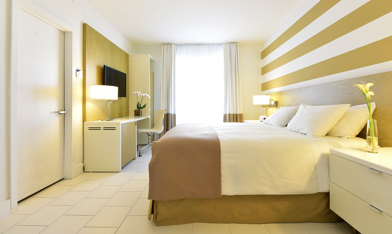 The Classic King at Pestana Miami South Beach has a double bed, bedside table, table, TV and closet