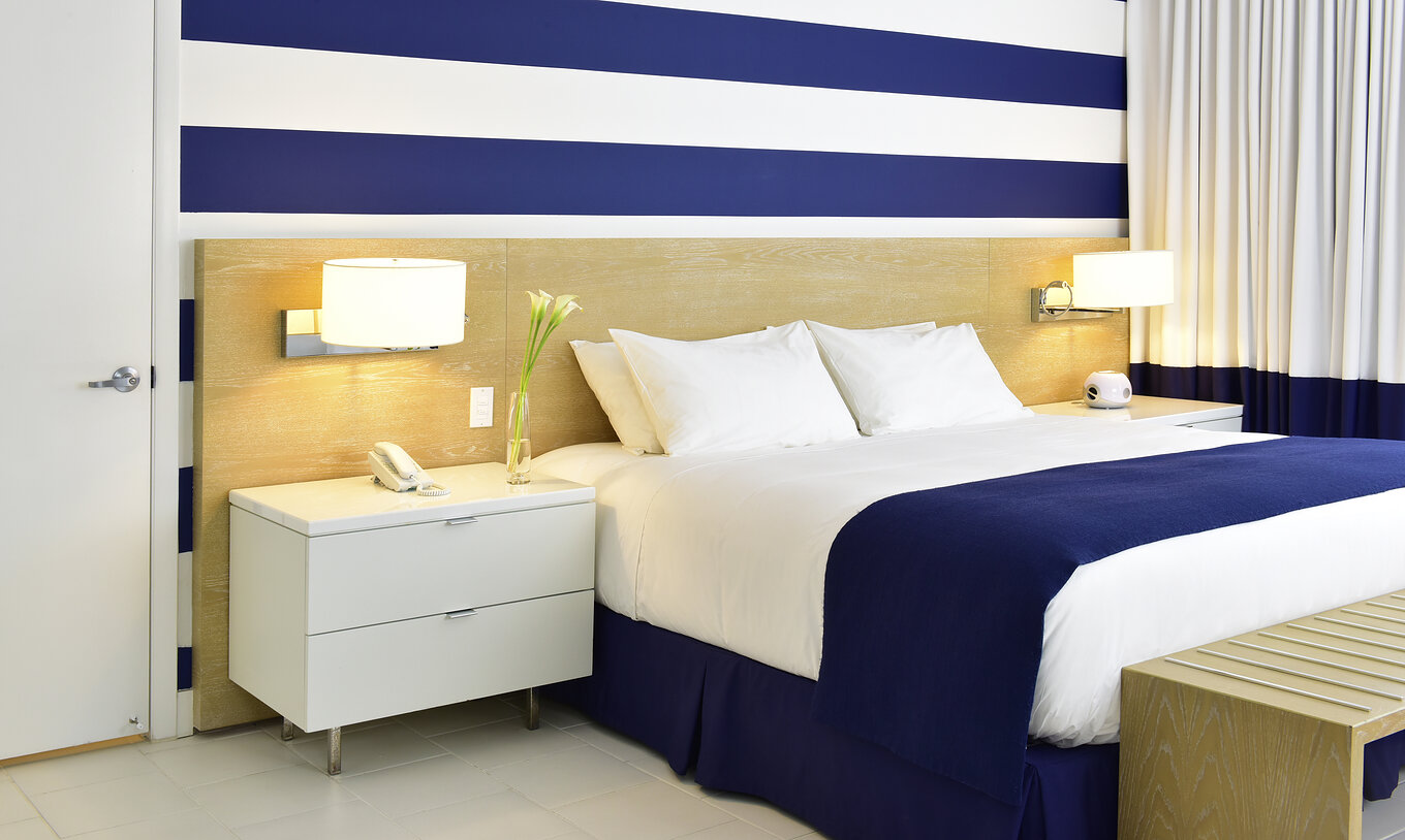 The Superior King, Pool View at Pestana Miami South Beach has a king size bed, lamp and bedside table