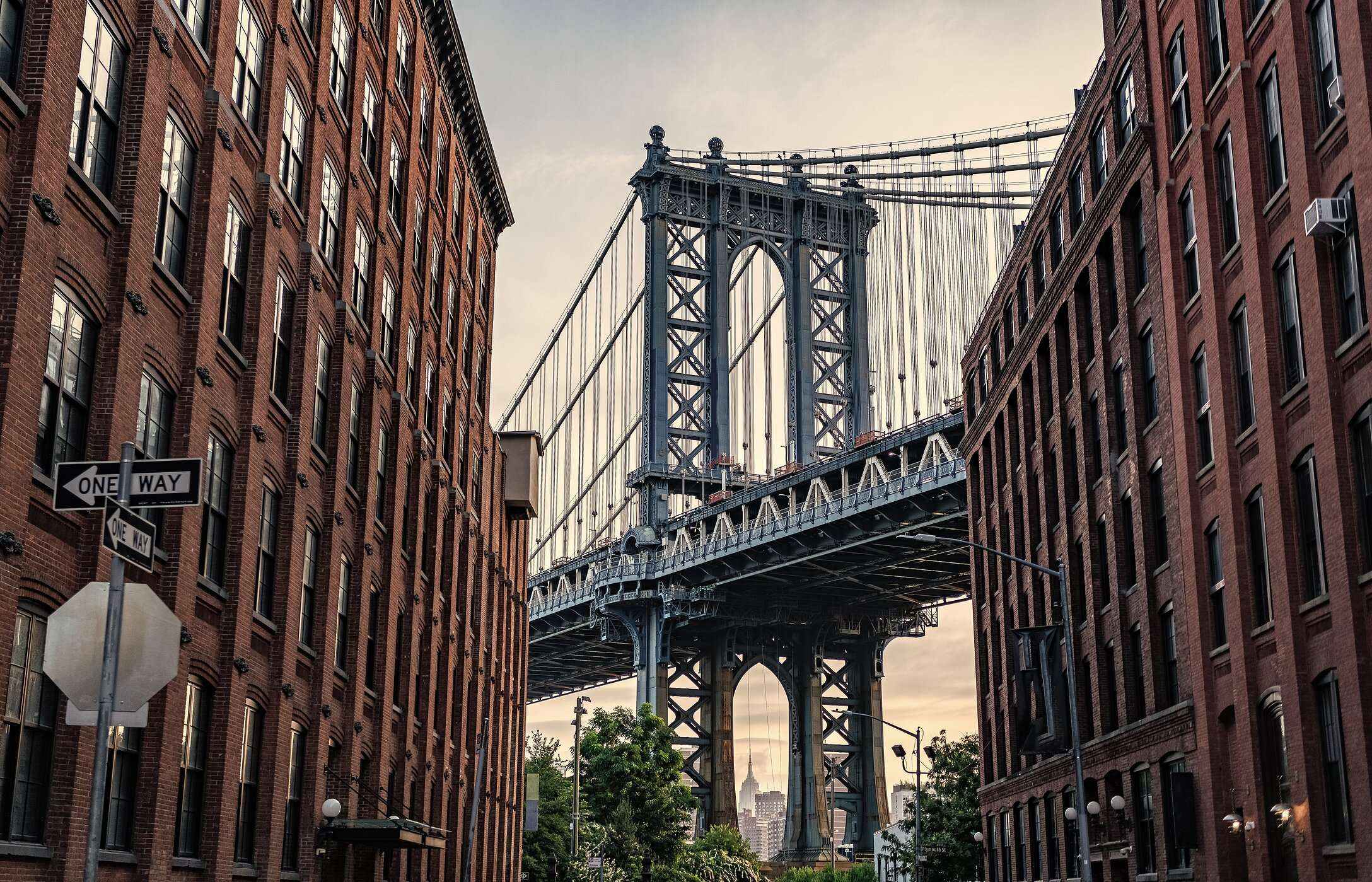 View of the iconic Brooklyn Bridge, between buildings, linking Manhattan to Brooklyn in New York City