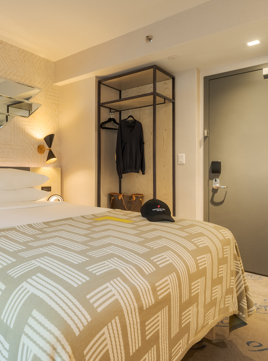 The Comfort ADA at Pestana CR7 Times Square has a double bed with a number seven quilt and a hanger
