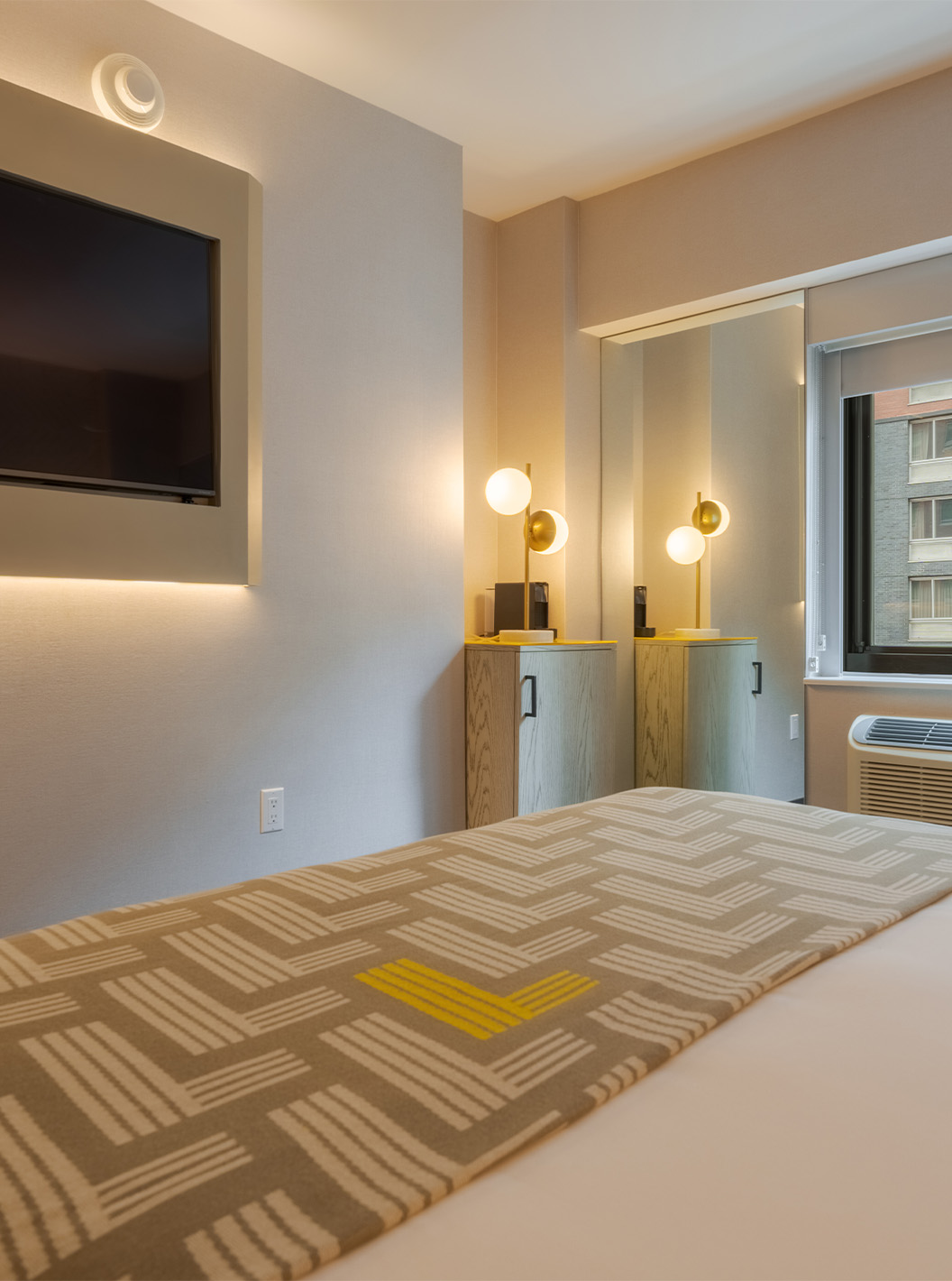 The Comfort at Pestana CR7 Times Square has a double bed with a bedspread with the number seven, a TV, and a window