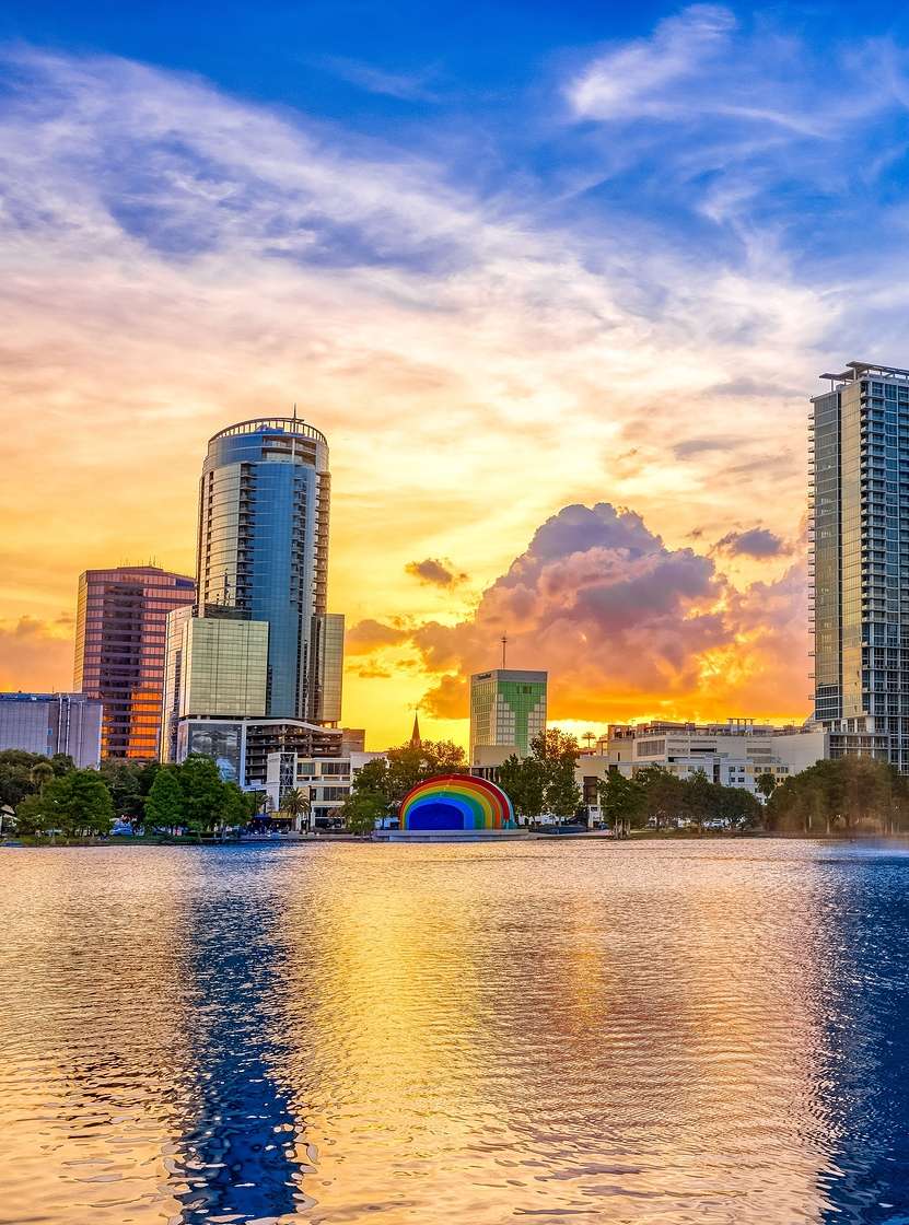 Urban landscape of Orlando at sunset, with a lake and a fountain in the foreground