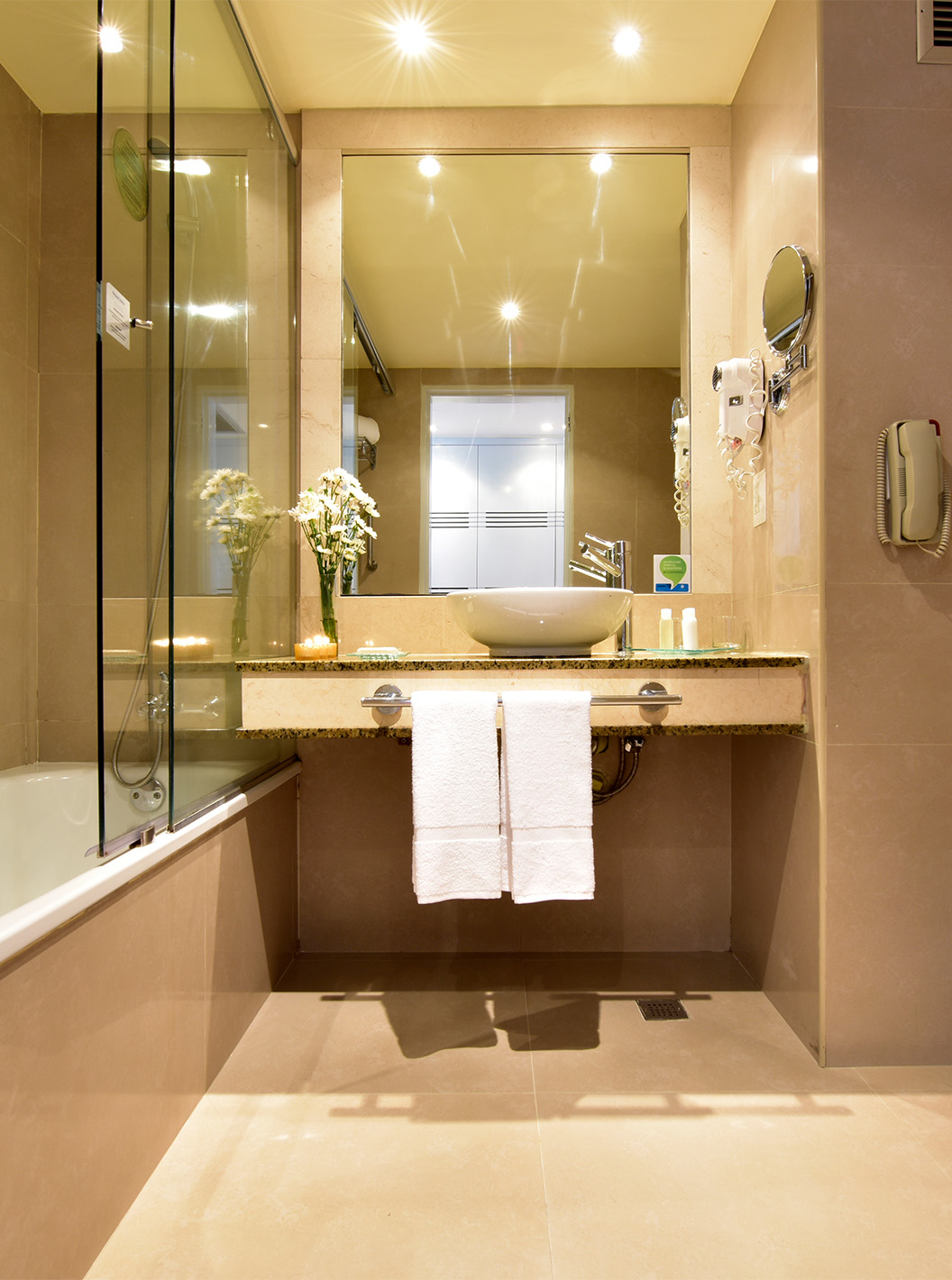 The Executive King Room at Pestana Caracas has a bathroom with a shower, sink with mirror, hairdryer, and toilet