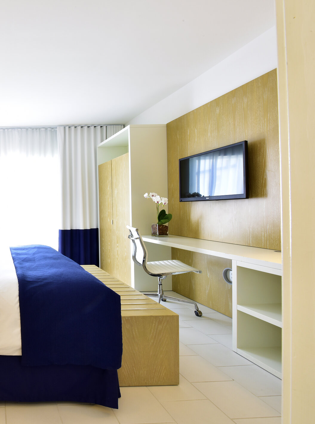 The Suite King with Balcony at Pestana Miami is modern with large bed and blue-white decor