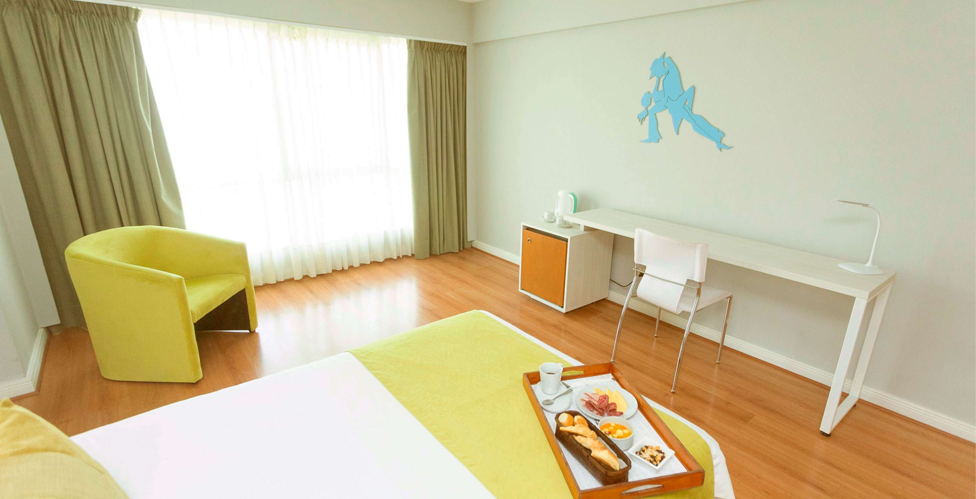 La Queen Superior del Pestana Buenos Aires cuenta con una silla, un escritorio y elementos decorativos