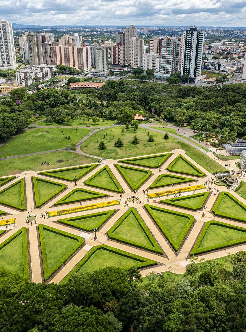 Vista aérea de Curitiba con parques verdes exuberantes y arquitectura moderna e imponente.