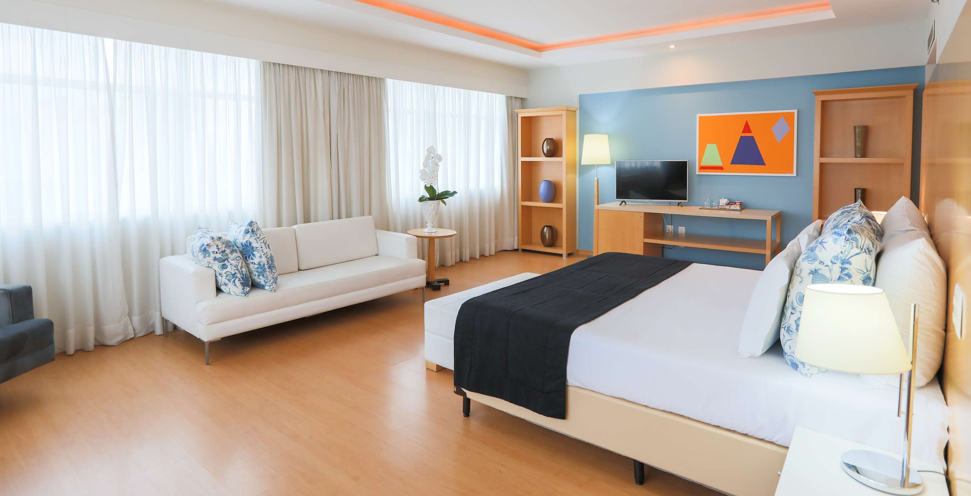 La Suite Ejecutiva del Pestana Curitiba es un cuarto amplio con ventanas, luminoso, con cama de matrimonio y sofá