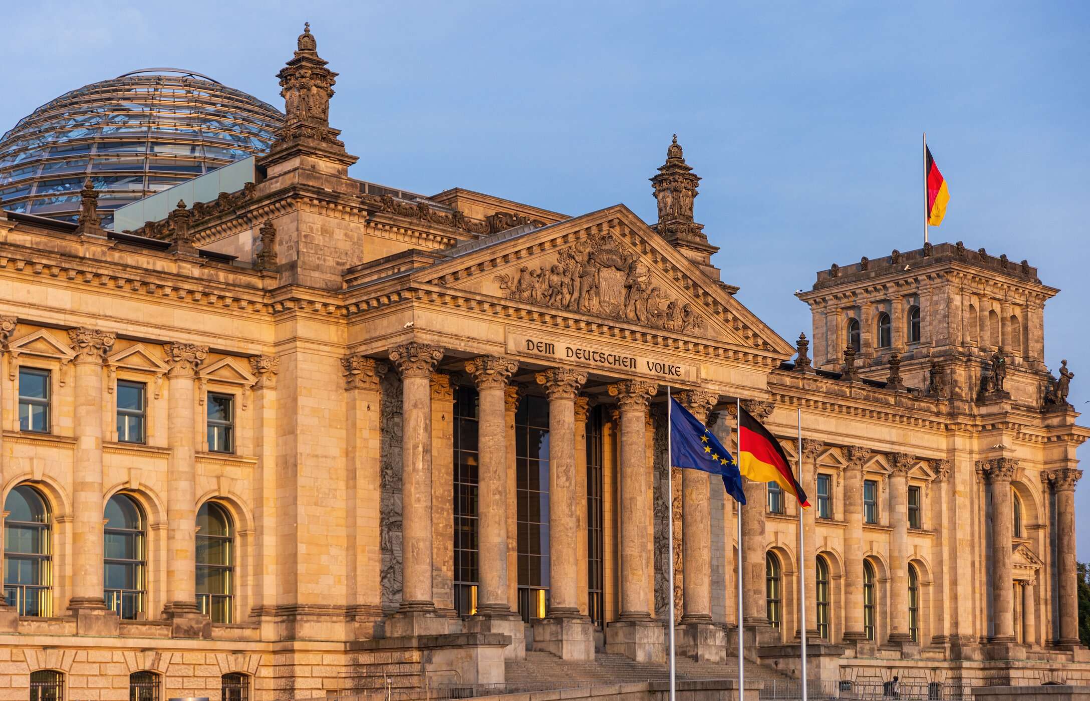 Vista frontal del Reichstag, la sede del parlamento alemán en Berlín, con una cúpula de vidrio y la bandera del país