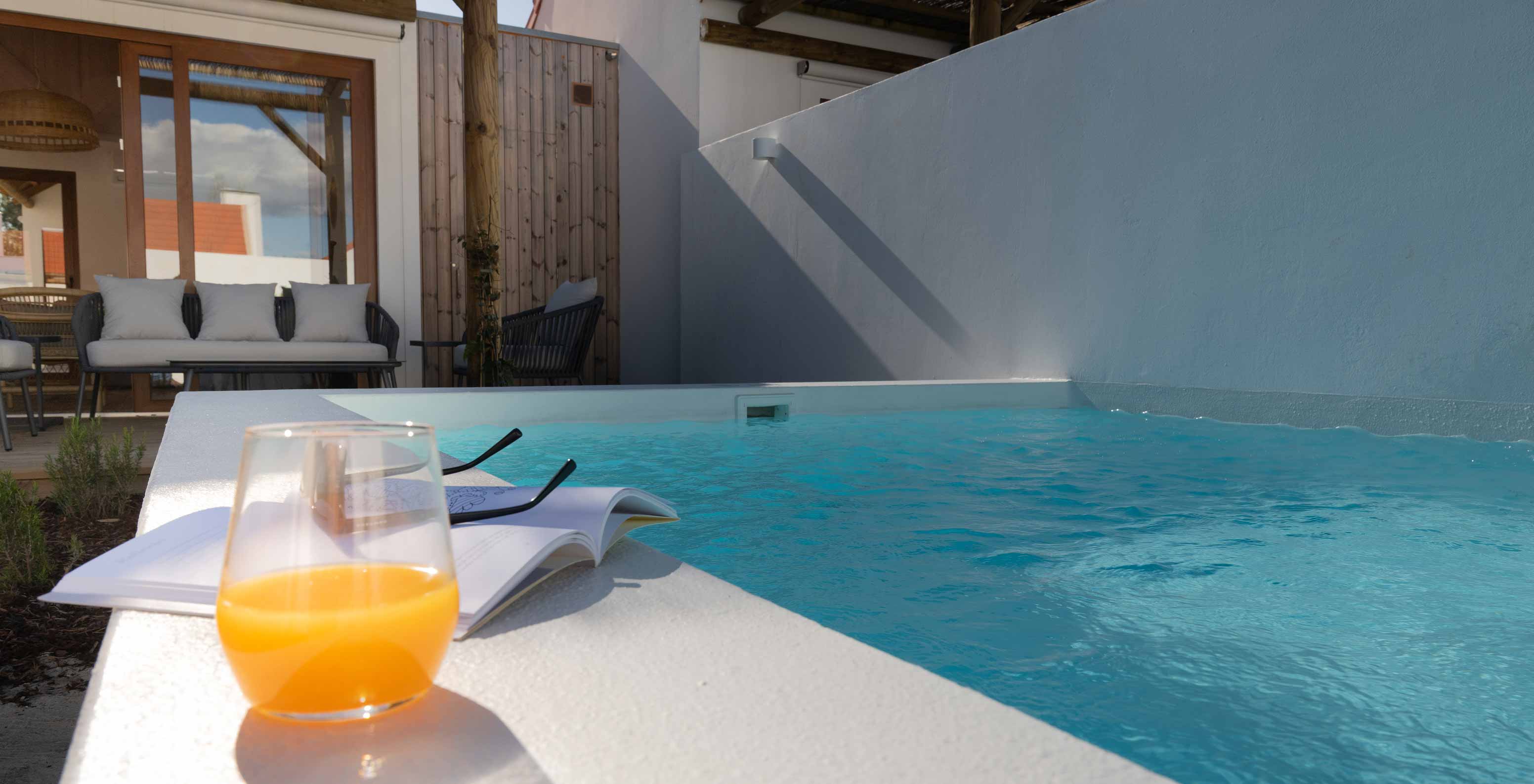 La Superior Green Villa de Pestana Comporta Village Residences tiene un patio con un vaso y un libro cerca de la piscina