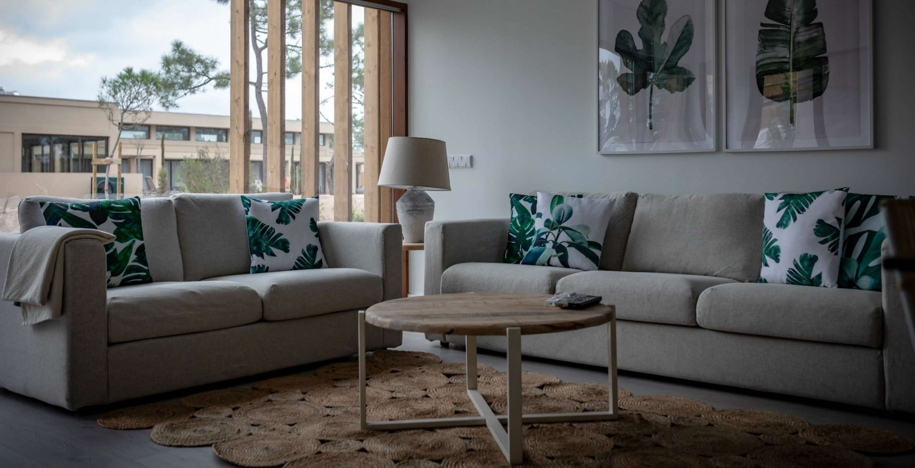 El Apartamento Eco Village Planta Baja del Pestana Tróia Eco Resort tiene una sala con dos sofás, mesa y cuadro de hojas