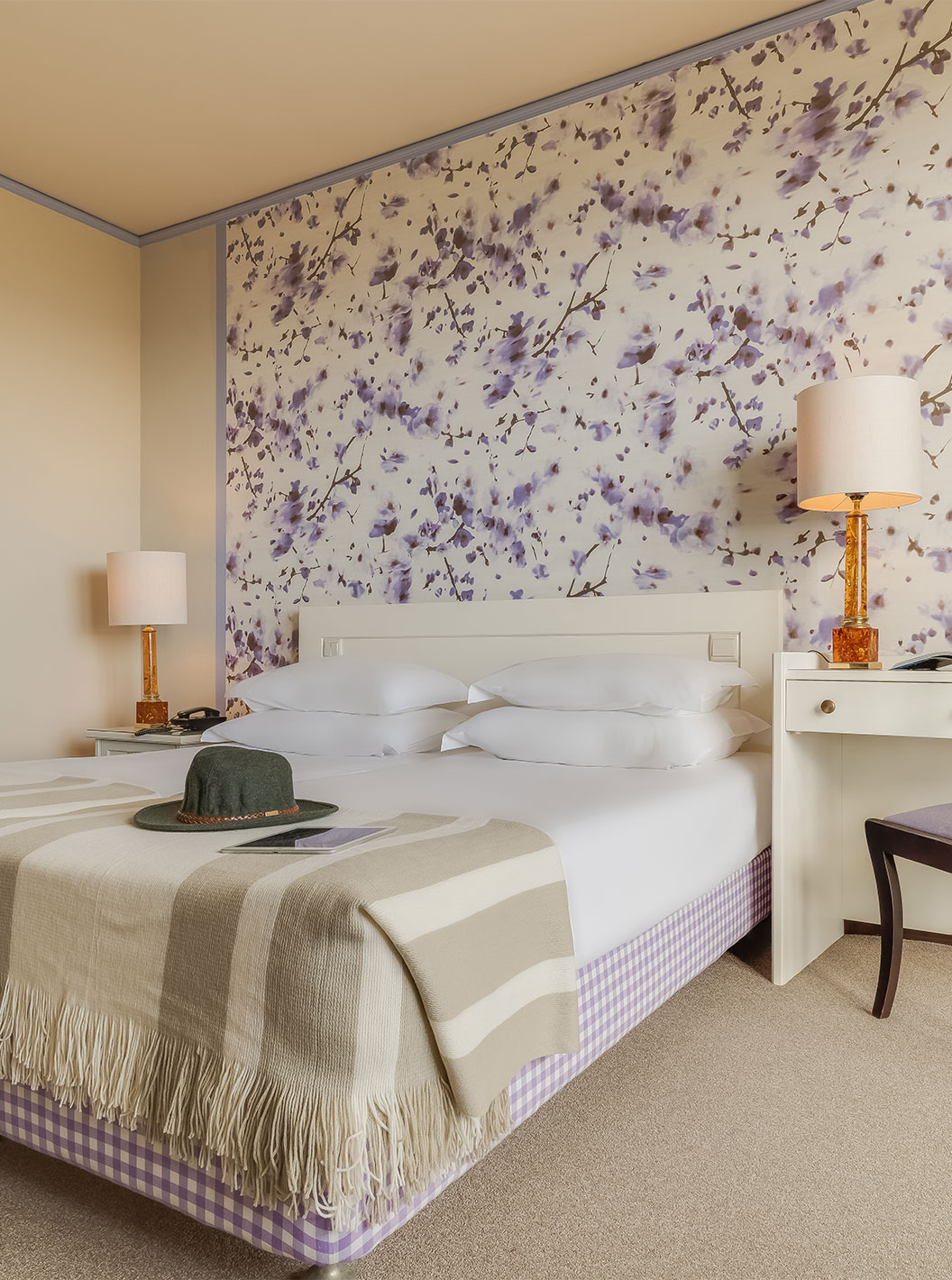 El Standard Vista Jardín del Pestana Bahia Praia tiene una cama con 4 almohadas y una mesa al lado de la cama con silla