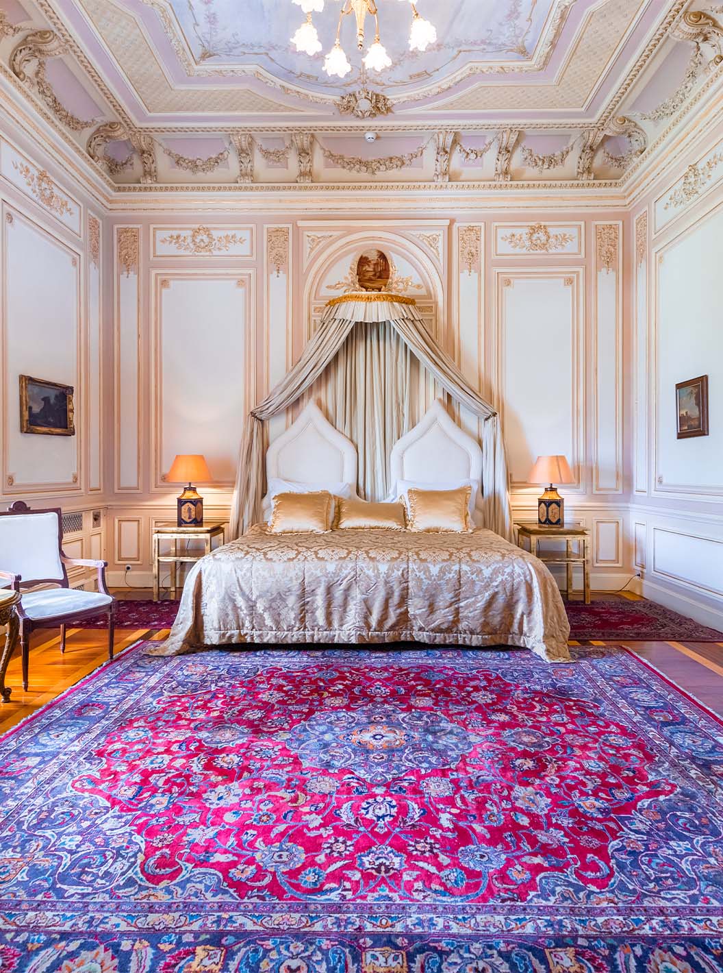 La Suite D. Carlos del Pestana Palace Lisboa tiene un dormitorio lujoso con cama y techo con detalles ornamentados