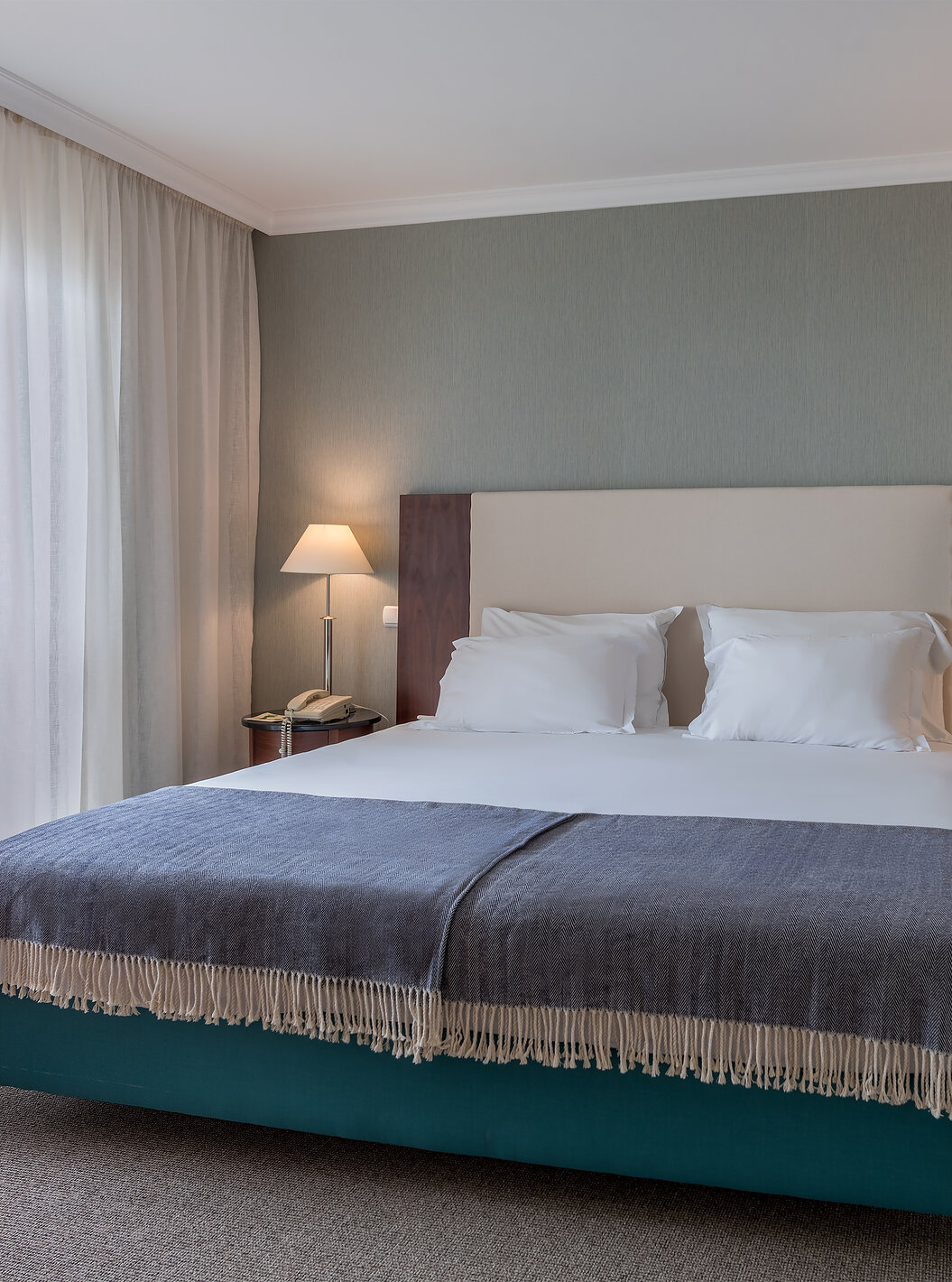 El cuarto Twin Superior Vista Mar del Pestana Grand tiene cama de matrimonio con mesita de noche y lámparas