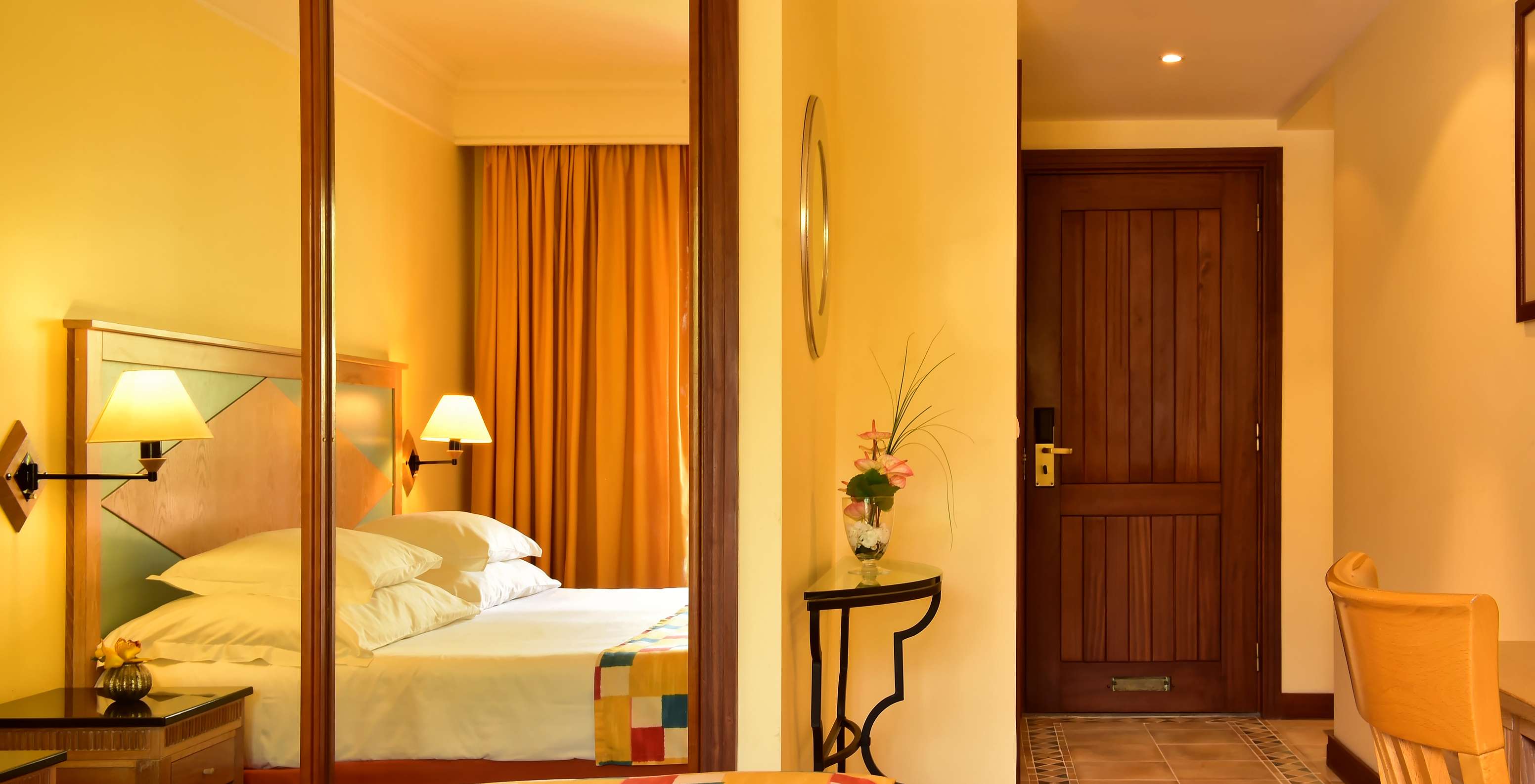 El Superior del Pestana Miramar tiene una cama matrimonial con una colcha a cuadros y un armario con espejo