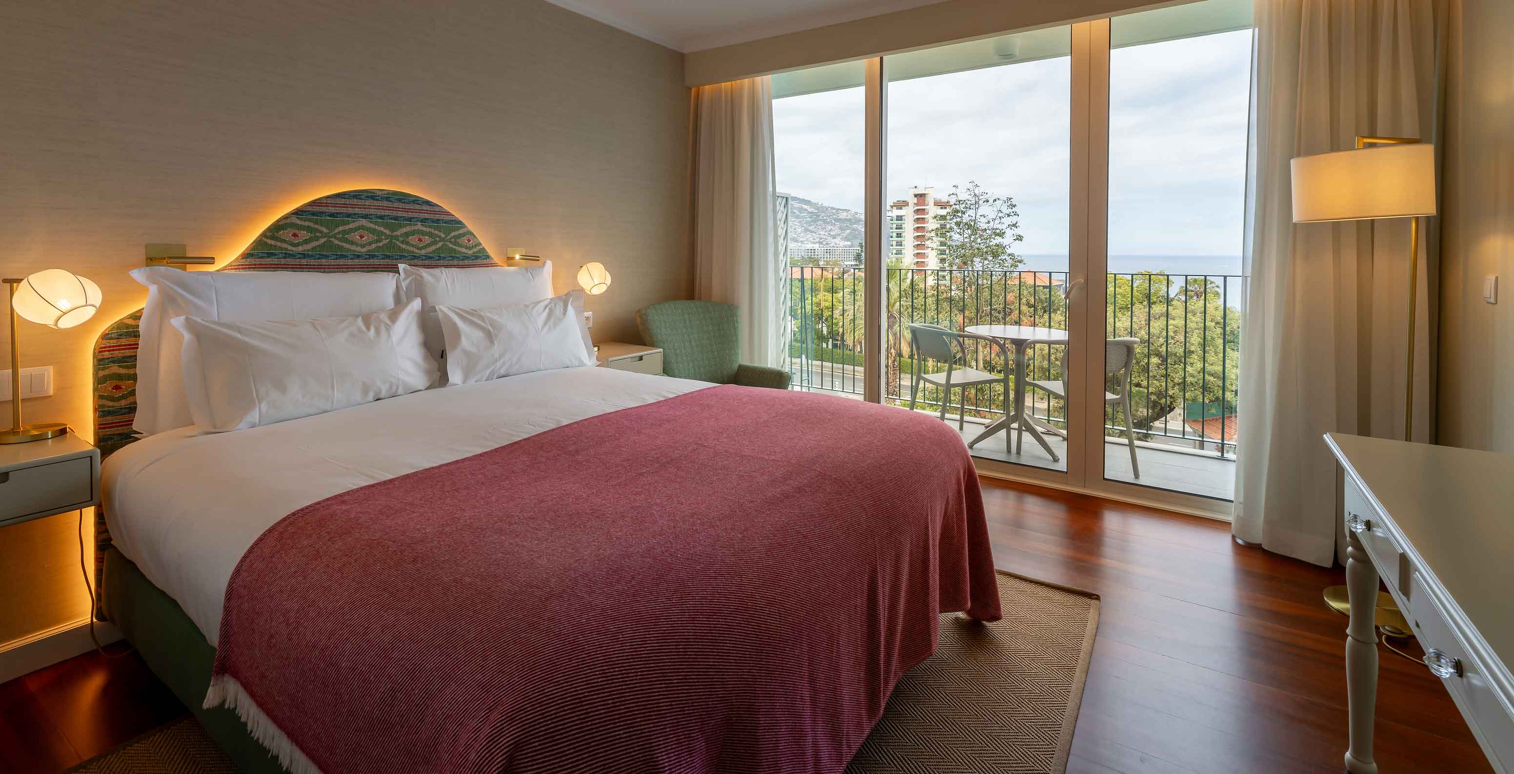 La Habitación Vista Mar Parcial del Pestana Quinta Perestrello tiene una cama doble, balcón con una mesa y vistas al mar.