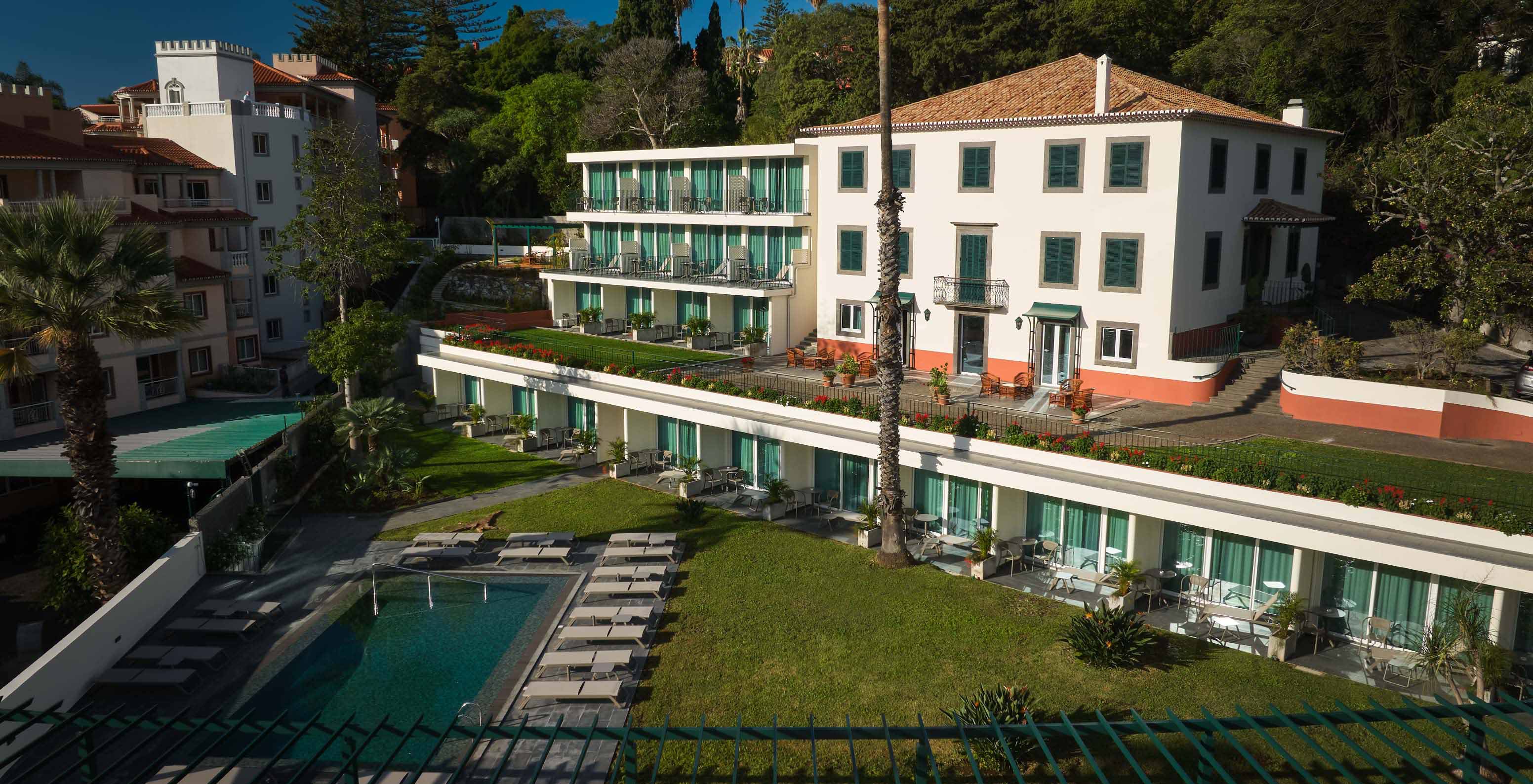 Vista del exterior del Pestana Quinta Perestrello, un Hotel con Encanto en Madeira, con la piscina al frente