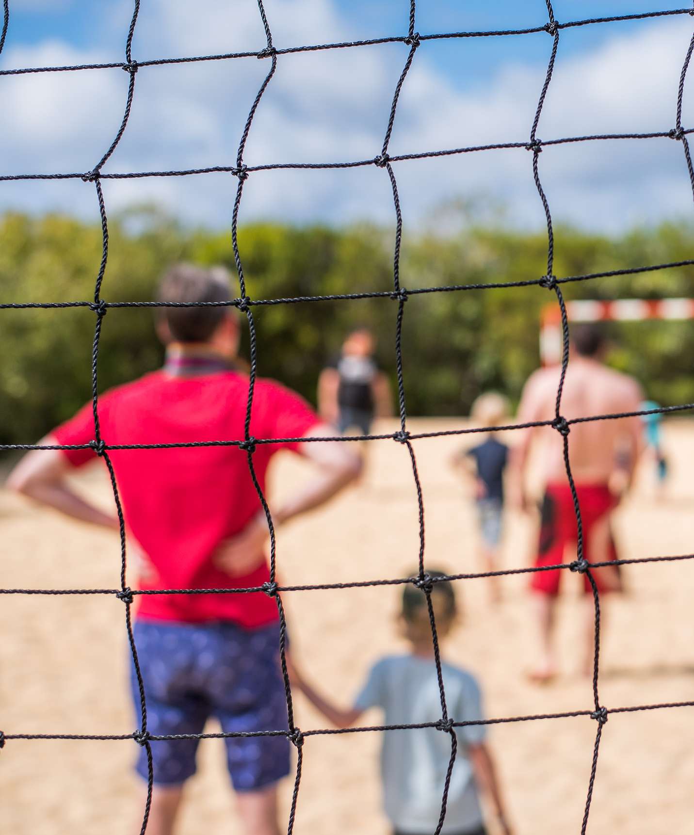 Campo de juegos en el hotel todo incluido y spa en Porto Santo, con padres e hijos jugando al fútbol en la playa