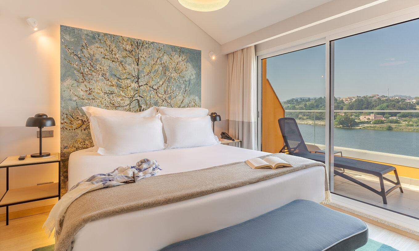 La Suite del Pestana Douro Riverside cuenta con una cama de matrimonio, terraza, mesa de noche con lámpara y teléfono