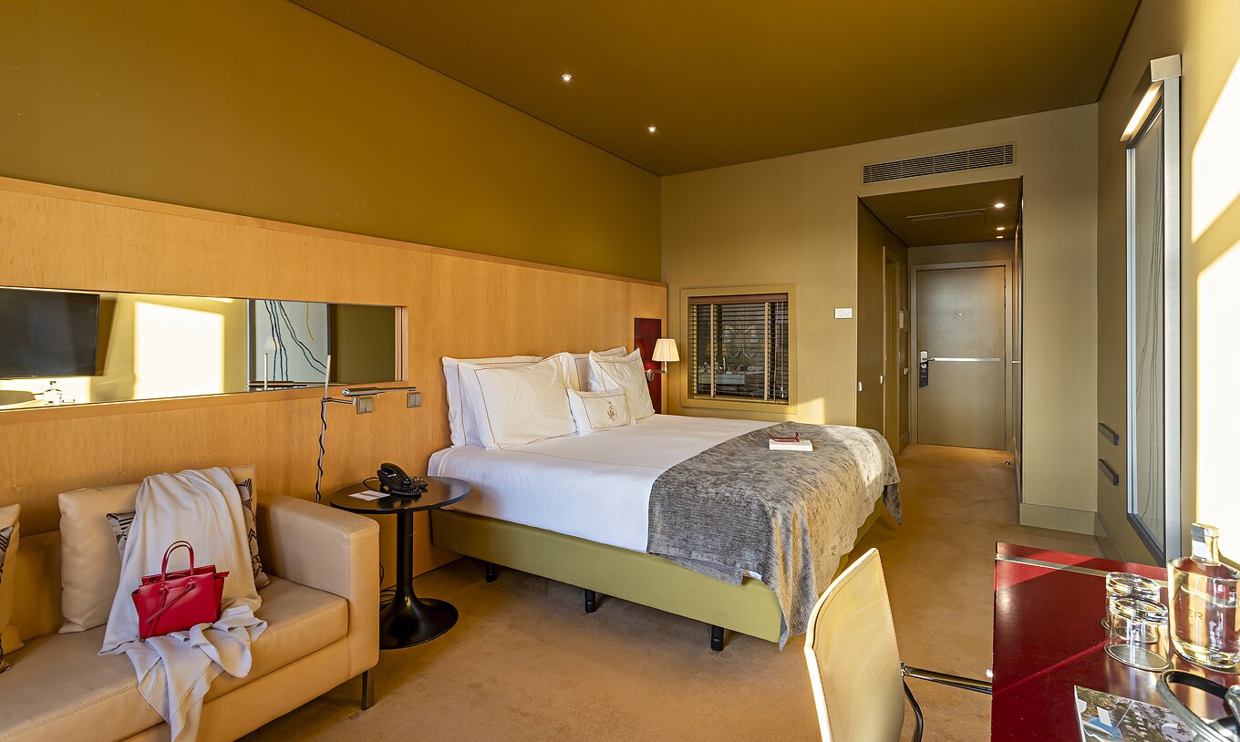 El Executive Superior tiene una cama doble, un sofá y un escritorio rojo