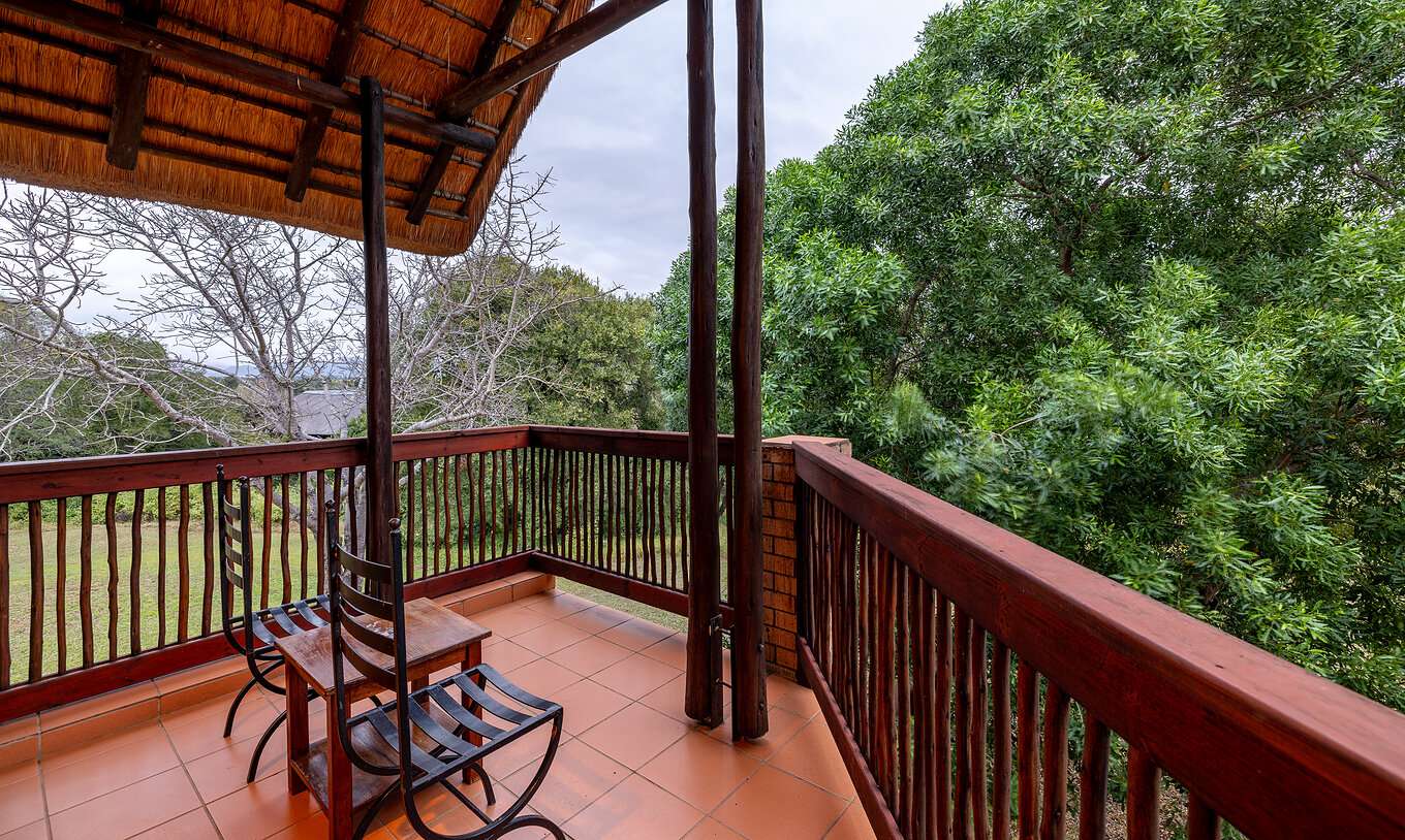 El Quarto Clássico del Pestana Kruger Lodge tiene una varanda con un corrimão de madera e com vista para o jardim
