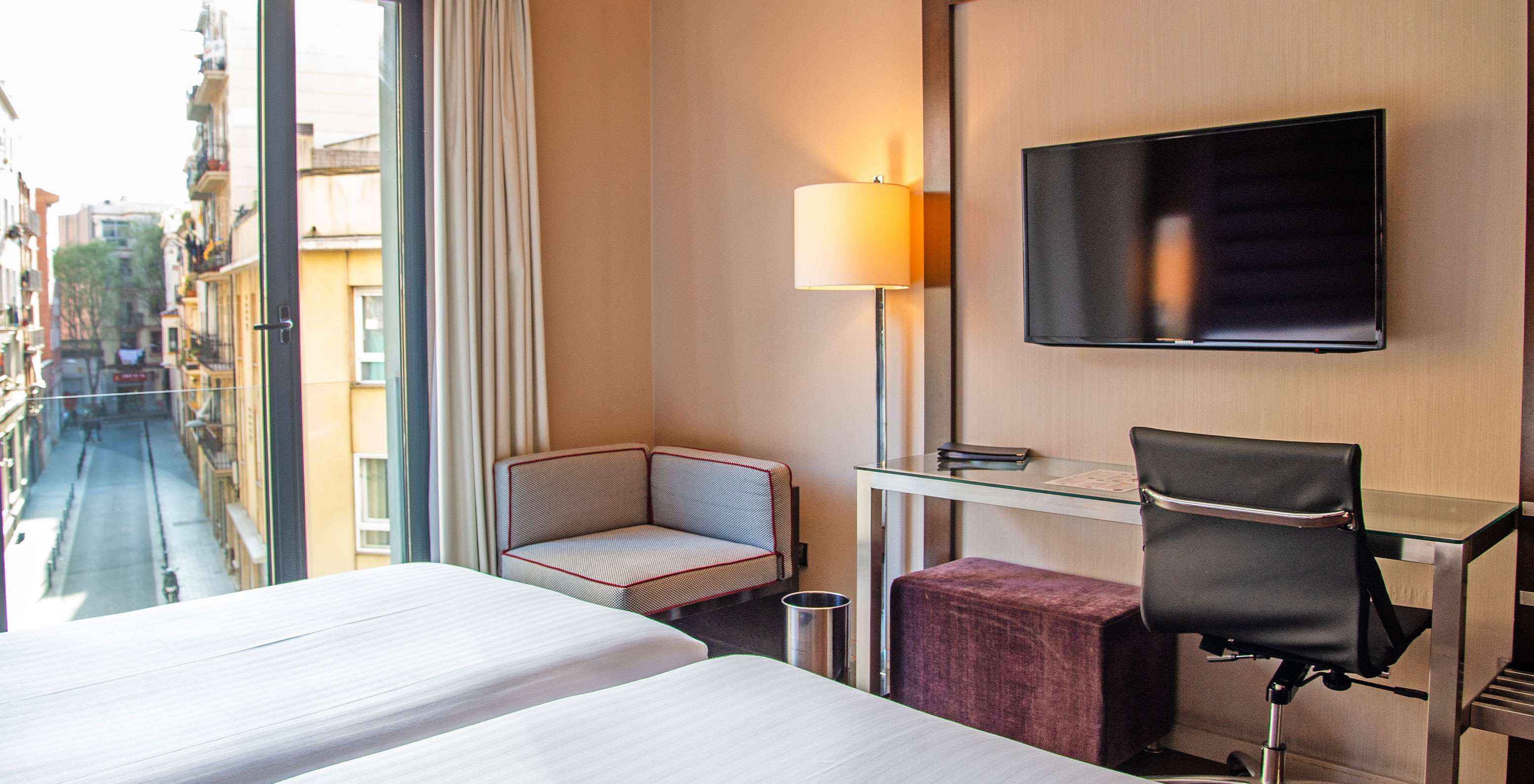 El cuarto Standard Twin del Pestana Arena Barcelona tiene escritorio, televisión y ventana con vista al centro de la ciudad