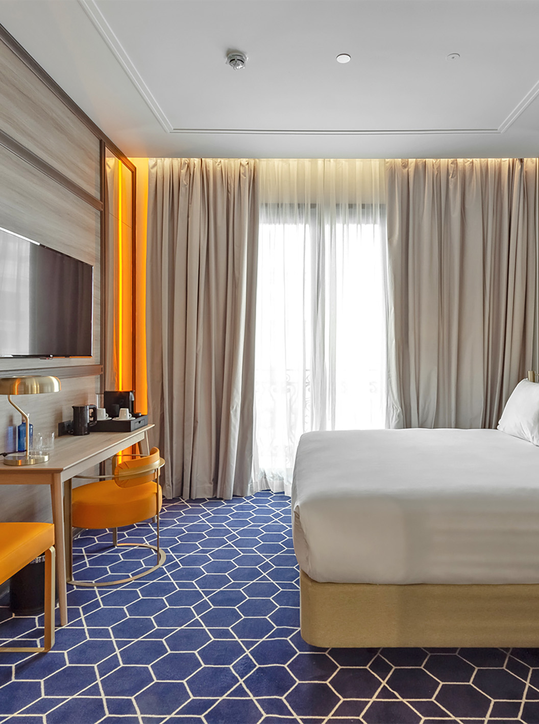 El Premium del Pestana CR7 Gran Vía Madrid tiene una cama doble con escritorio y silla, televisión y ventana con cortinas