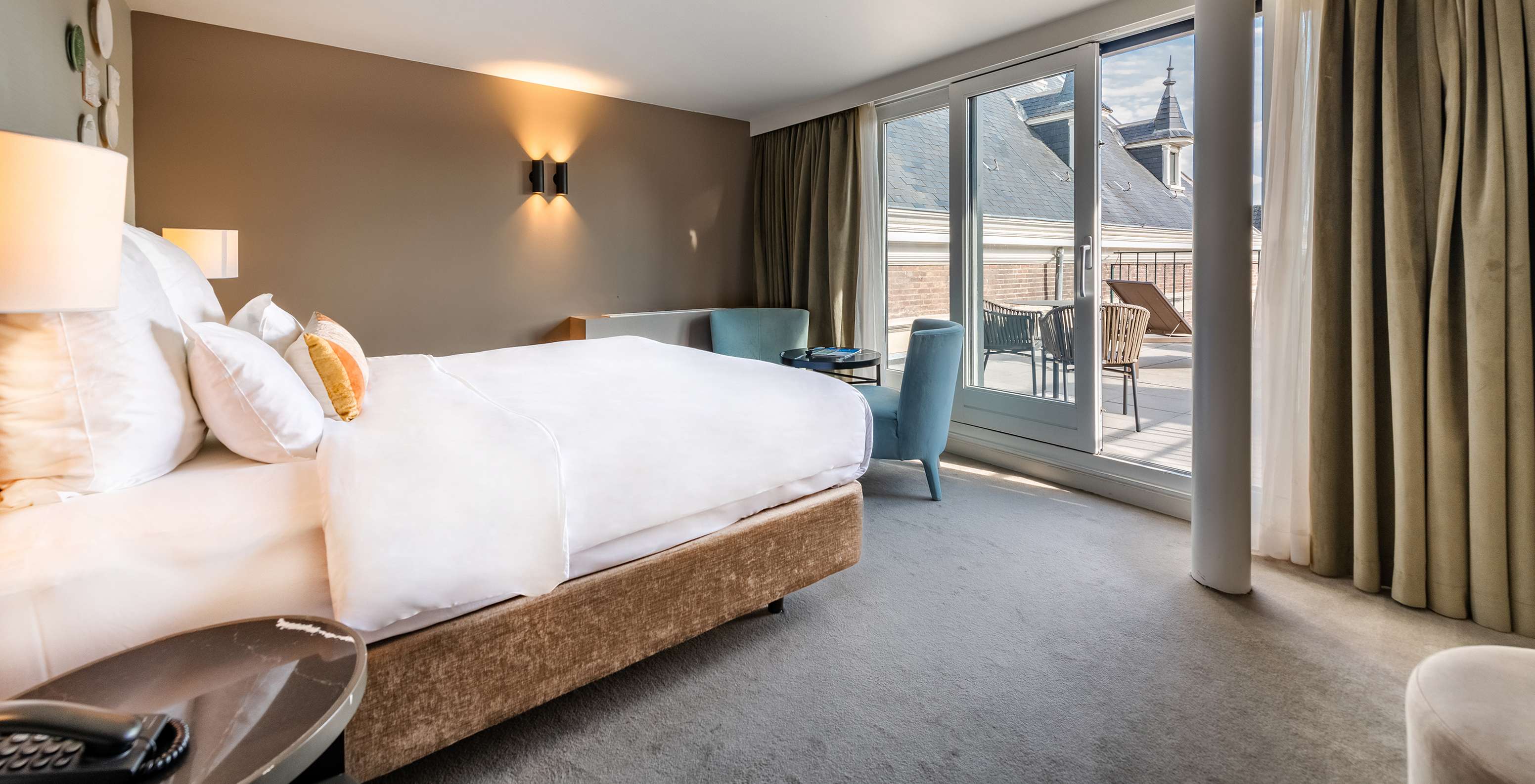 El cuarto Superior con Terraza del Pestana Amsterdam Riverside tiene una cama doble con vista al balcón, y dos sillones