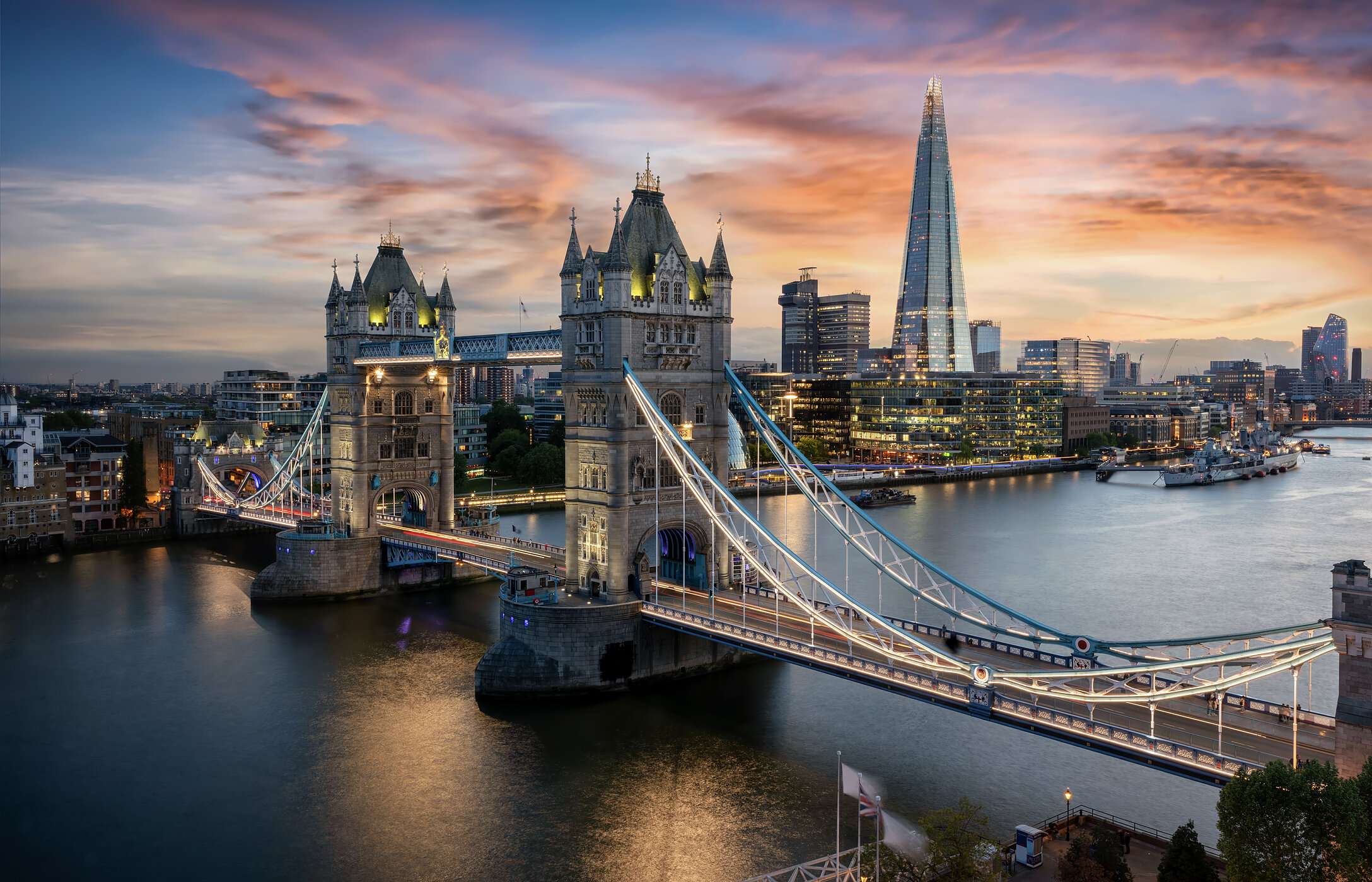 Vista aérea del Tower Bridge en Londres, Reino Unido, sobre el río Támesis, con edificios iluminados.