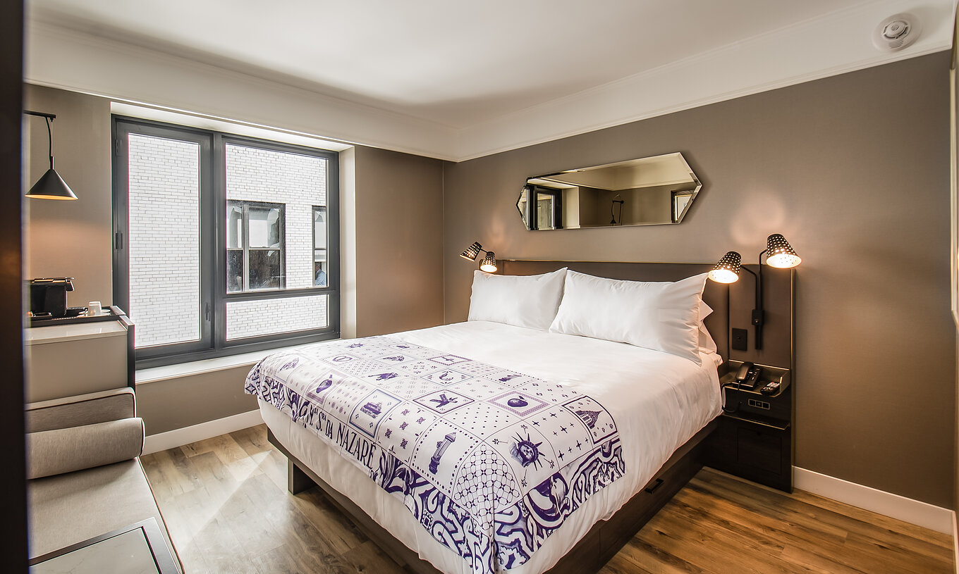 La habitación Clásica - ADA del Pestana Park Avenue cuenta con una cama de casal, con mesa de noche con lámpara y teléfono