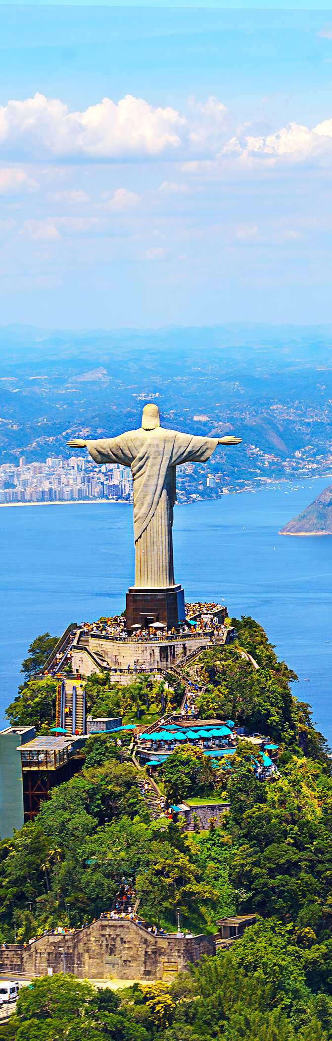 Icónica estatua del Cristo Redentor en Río de Janeiro, con la ciudad, el océano y la playa de fondo.