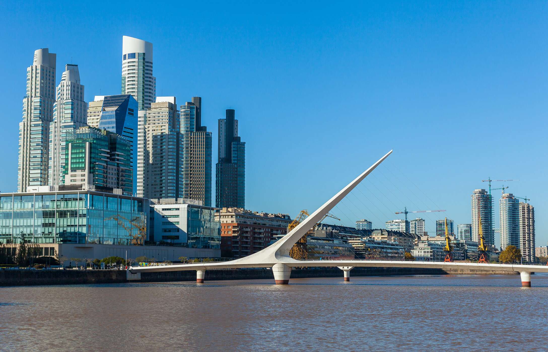 De iconische Women's Bridge, in zeilvorm, over een rivier in Buenos Aires, met Puerto Madero op de achtergrond