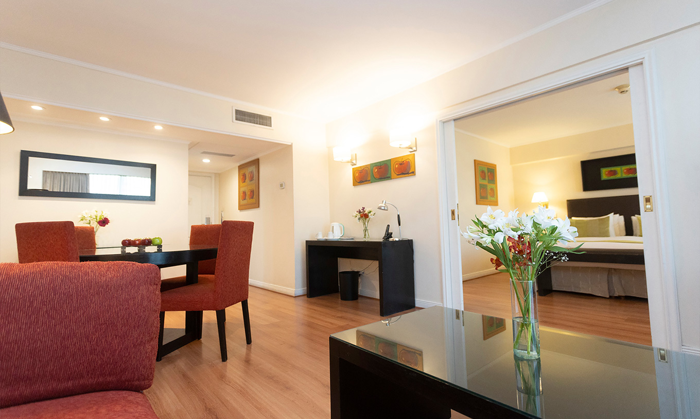 De Suite van Pestana Buenos Aires heeft tafel met stoelen, spiegel, telefoon en salontafel