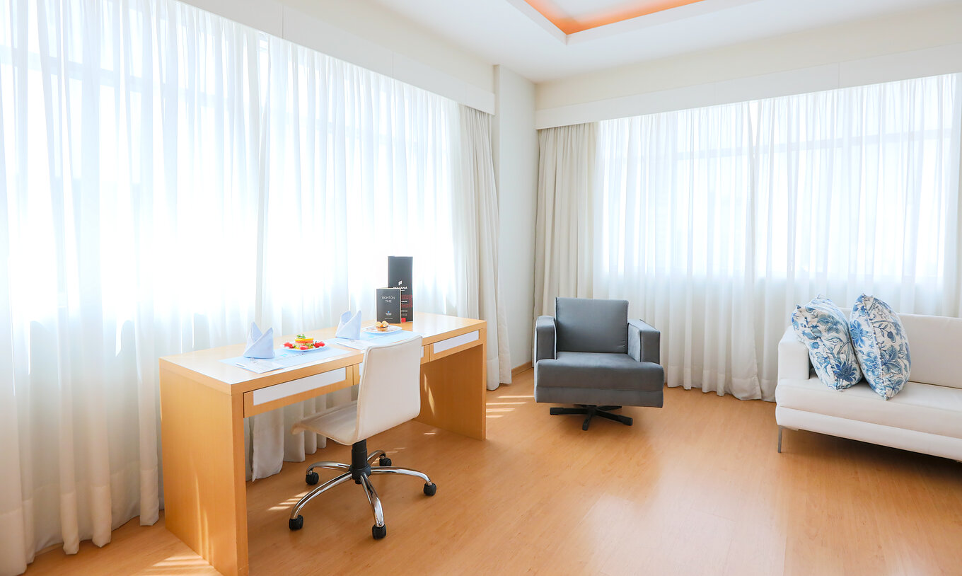 De Deluxe Hoek van Pestana Curitiba heeft banken en bureau bij twee grote ramen die veel licht binnenlaten