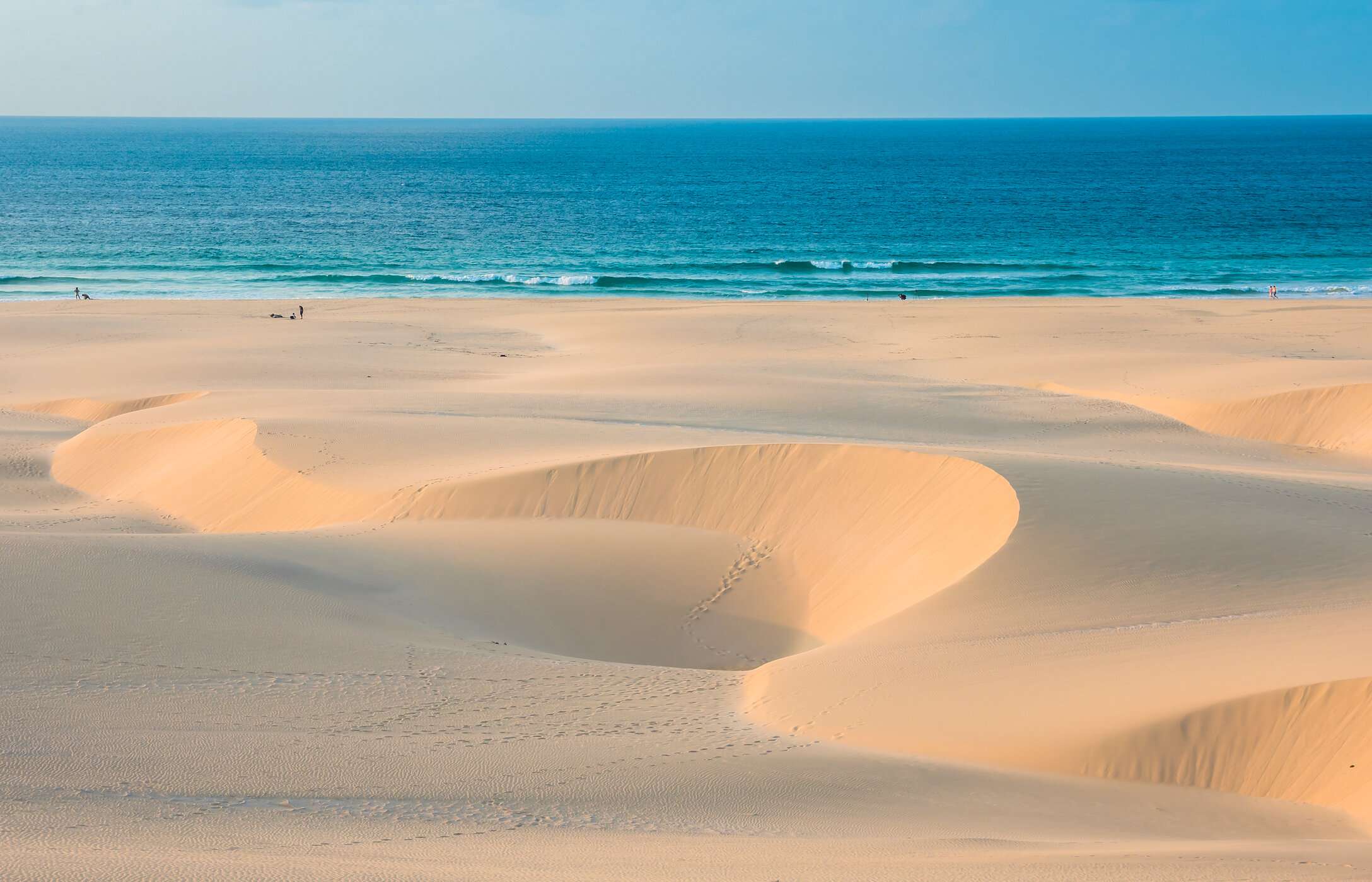 Panoramisch uitzicht op Chaves Beach met door de wind gevormde zandduinen in contrast met de turquoise blauwe zee