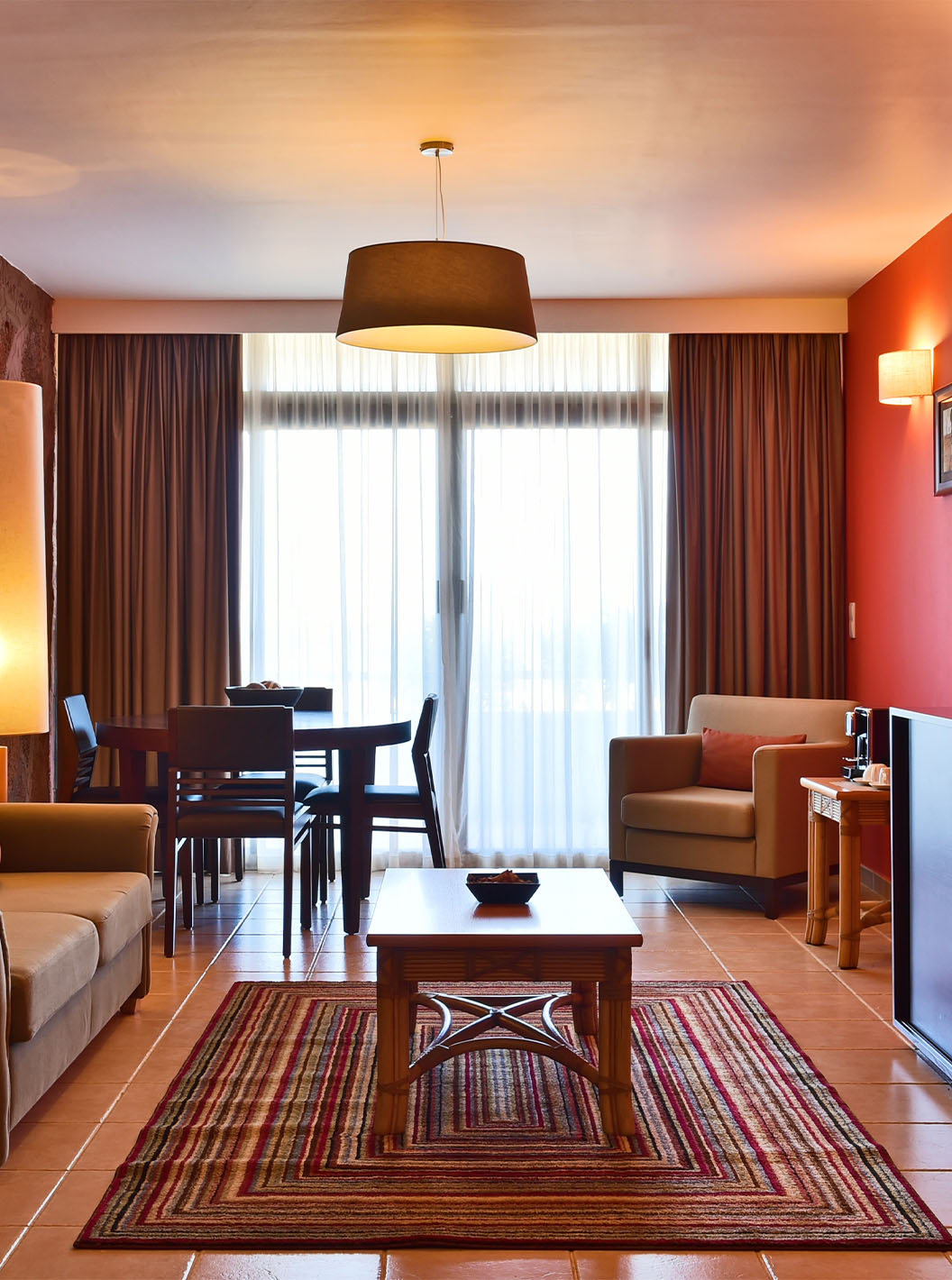 De Suite Premium van Pestana Tropico heeft een woonkamer met bank, eettafel, fauteuil en salontafel