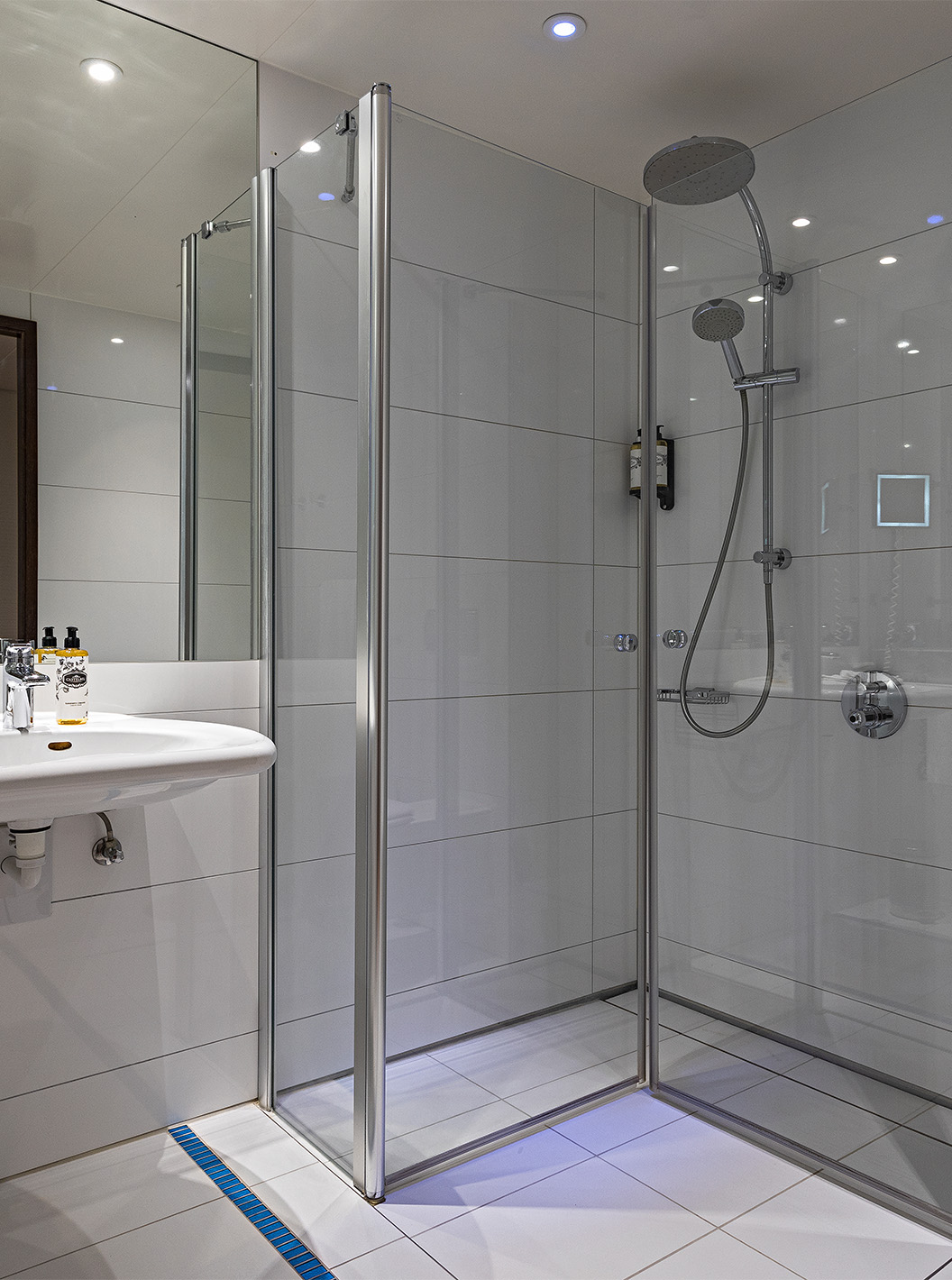 De Deluxe Kamer met Terras van Pestana Berlin Tiergarten heeft badkamer met douche, wastafel en spiegel