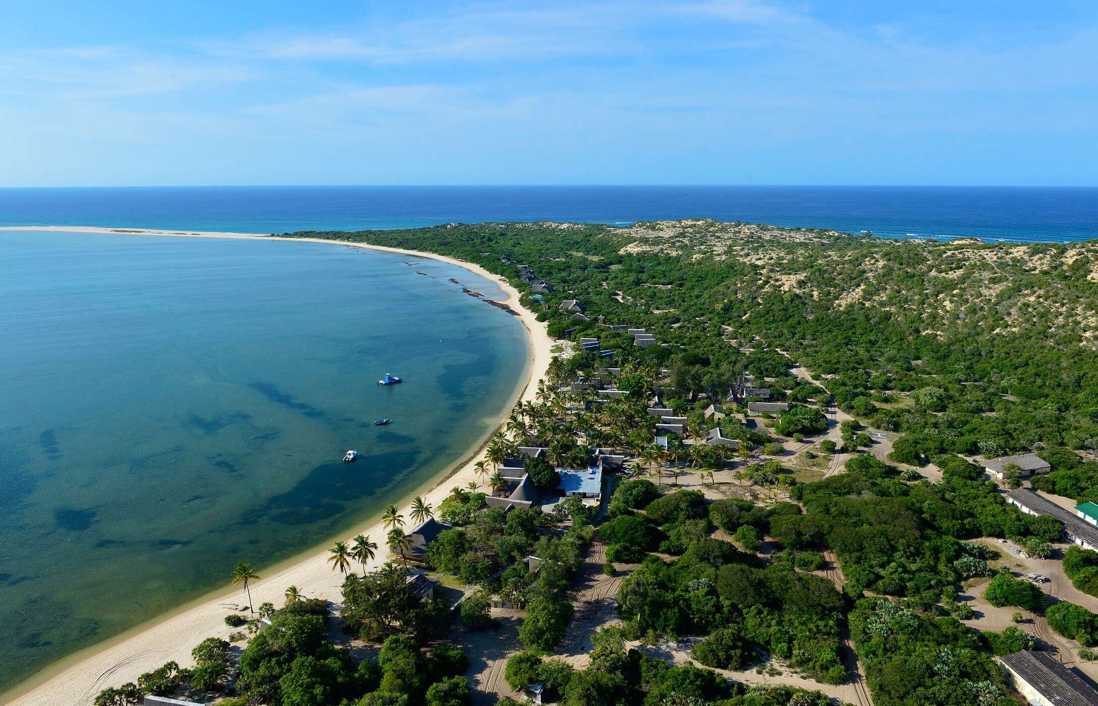 Luchtzicht op het eiland Bazaruto in Mozambique, met een wit zandstrand, omgeven door vegetatie en enkele gebouwen.