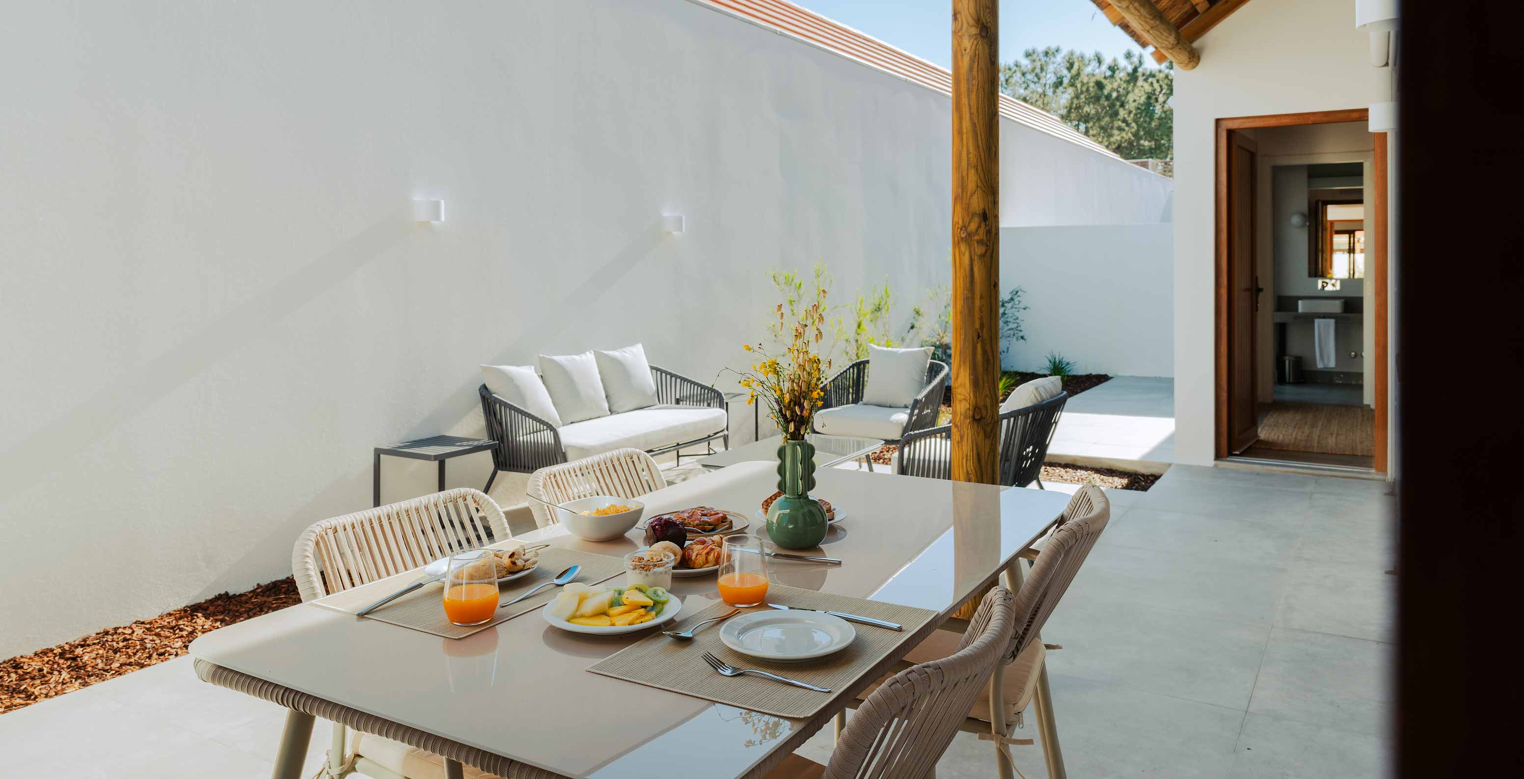 De Superieure Villa bij Pestana Comporta Village Residences heeft een buitenpatio met een eettafel en een bank