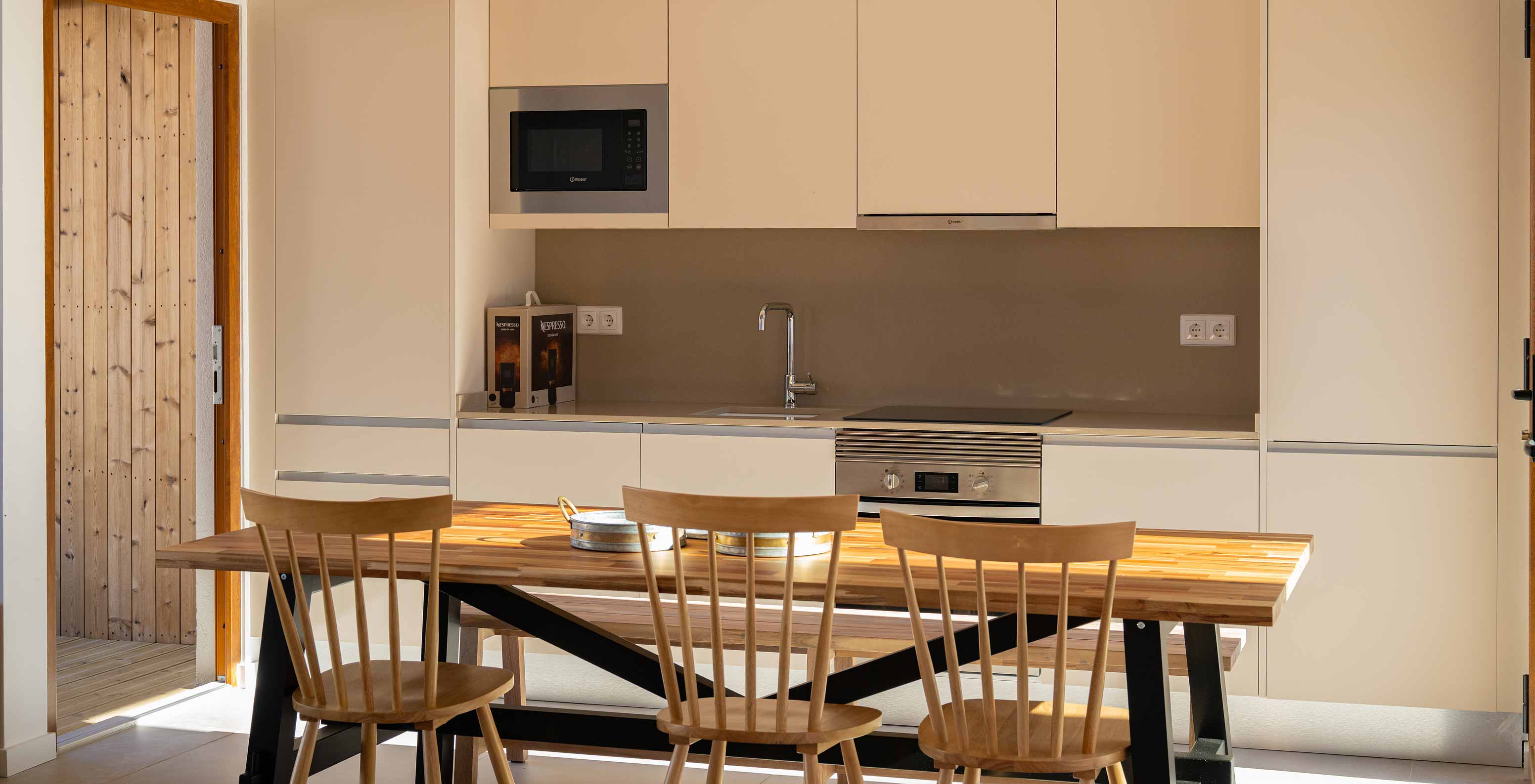 De Superieure Villa bij Pestana Comporta Village Residences heeft een moderne keuken met een houten tafel en een oven