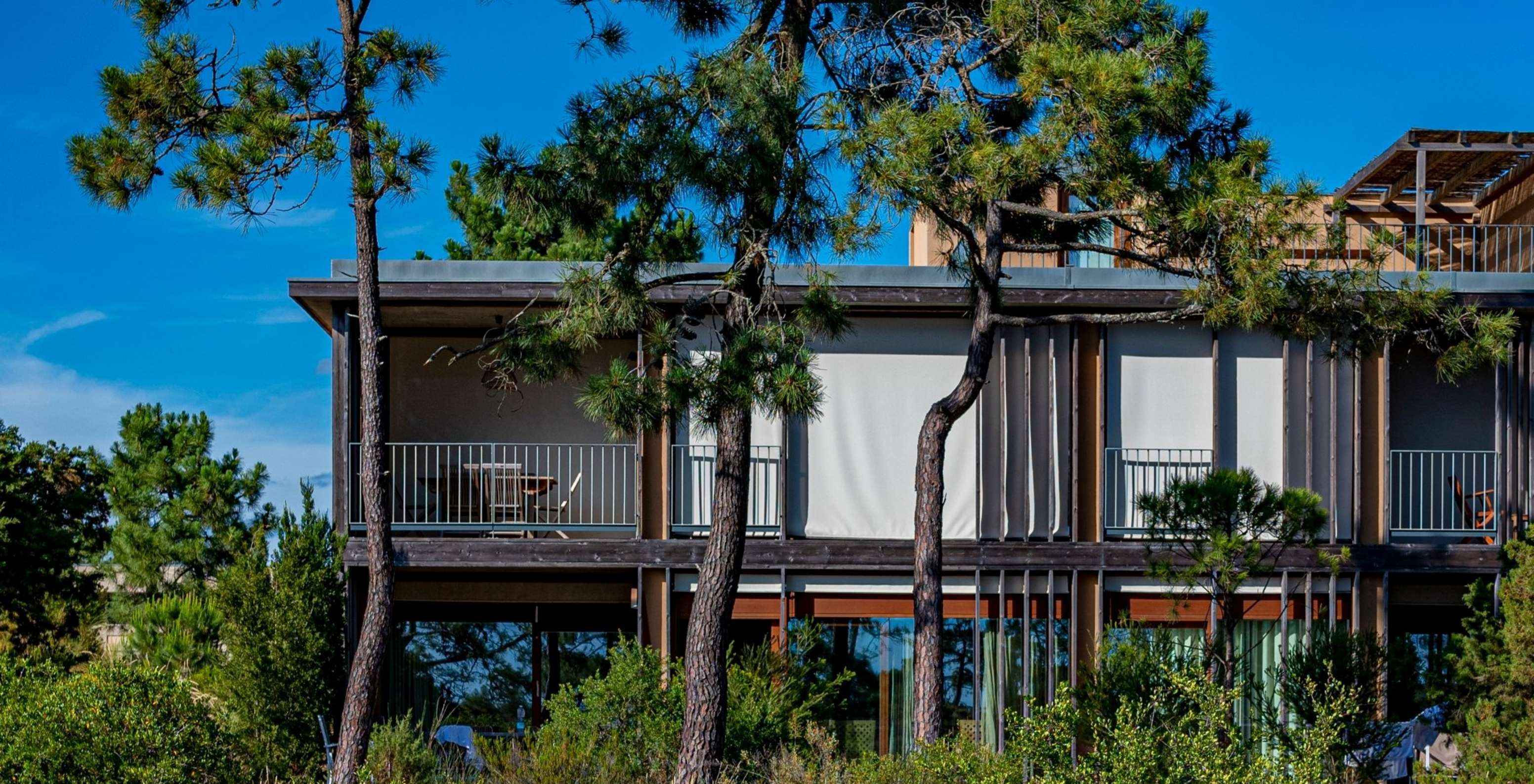 Het Eco Village Superior Appartement 1e Verdieping Vistas Premium van Pestana Tróia Eco Resort heeft bomen rondom de villa