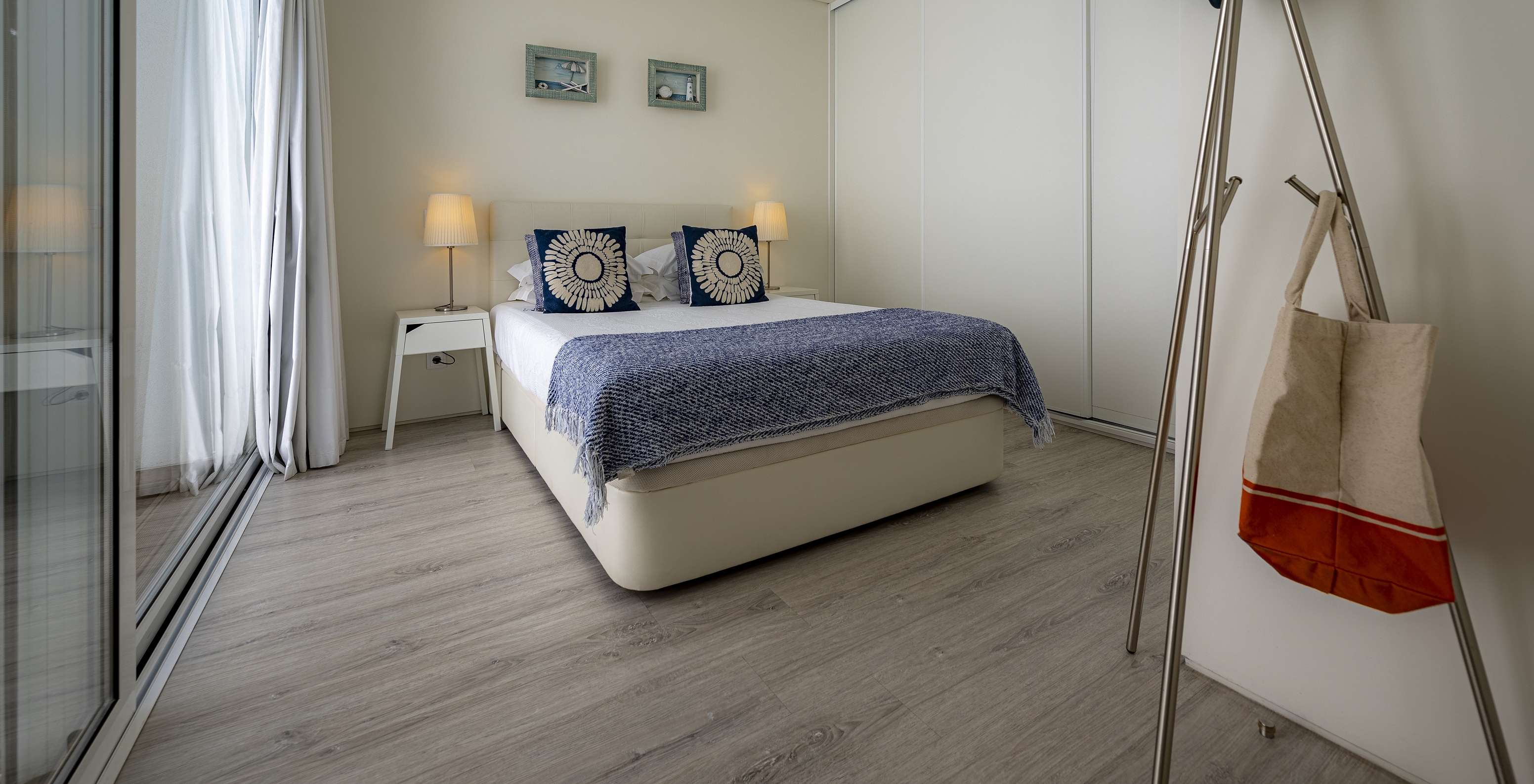 De Green Villa van Pestana Tróia Eco Resort heeft een tweepersoonsbed met twee nachtkastjes en een blauwe dekbed