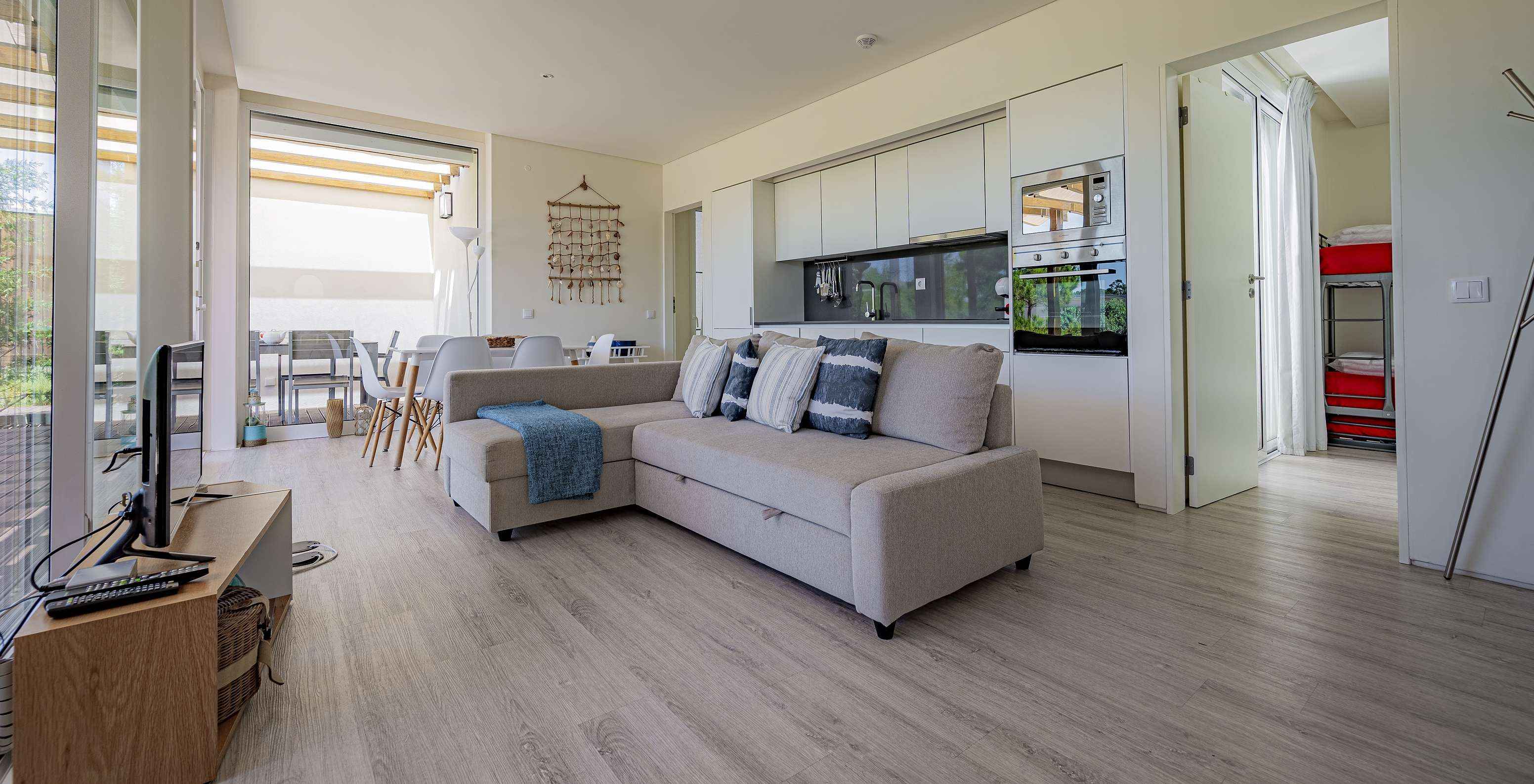 De Green Villa van Pestana Tróia Eco Resort heeft een gecombineerde woonkamer met keuken, bank, eettafel en televisie