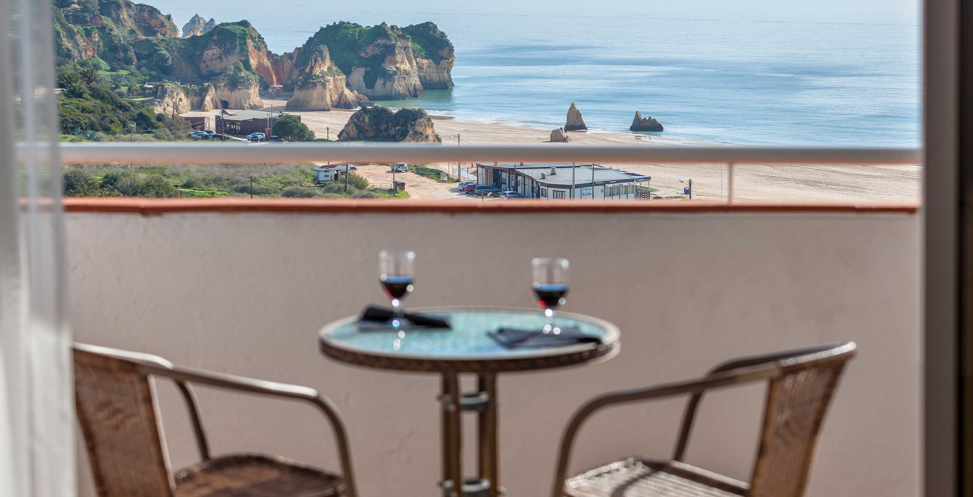 Het T1 Appartement Vista Mar van Pestana Alvor Atlântico heeft een balkon met uitzicht op zee, een tafel en twee stoelen