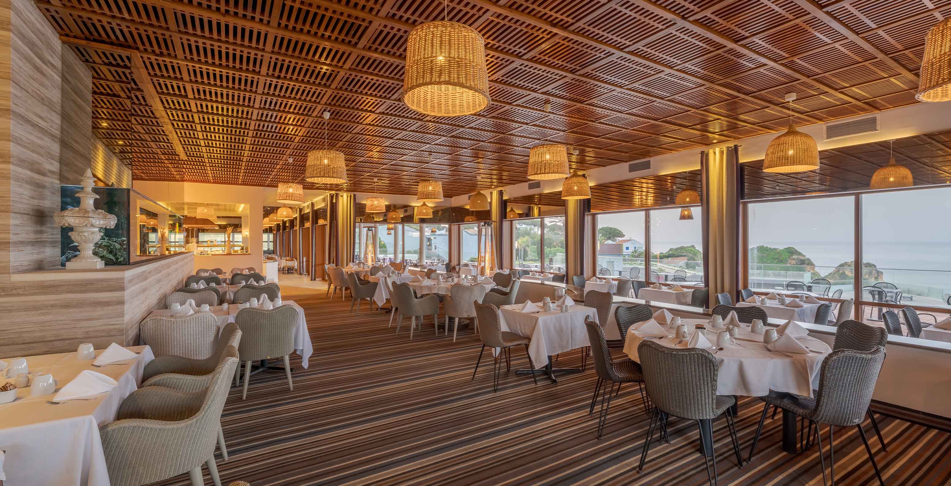 Het restaurant Almofariz, van het 5-sterrenhotel in de Algarve, heeft houten latten aan het plafond en uitzicht op zee