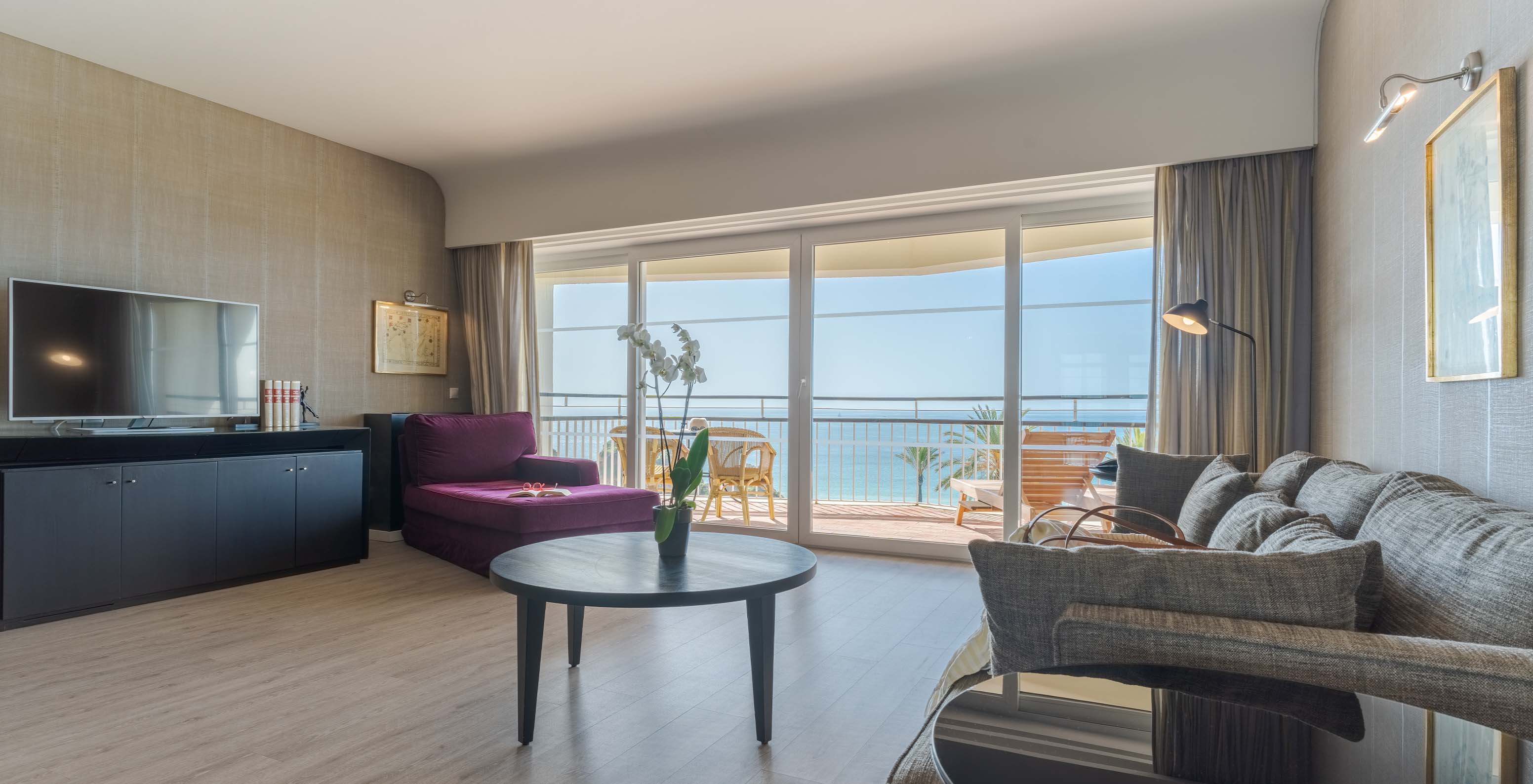 De Suite Luxe met uitzicht op de zee van Pestana Alvor Praia heeft woonkamer met bank, fauteuil, tafel, televisie en balkon