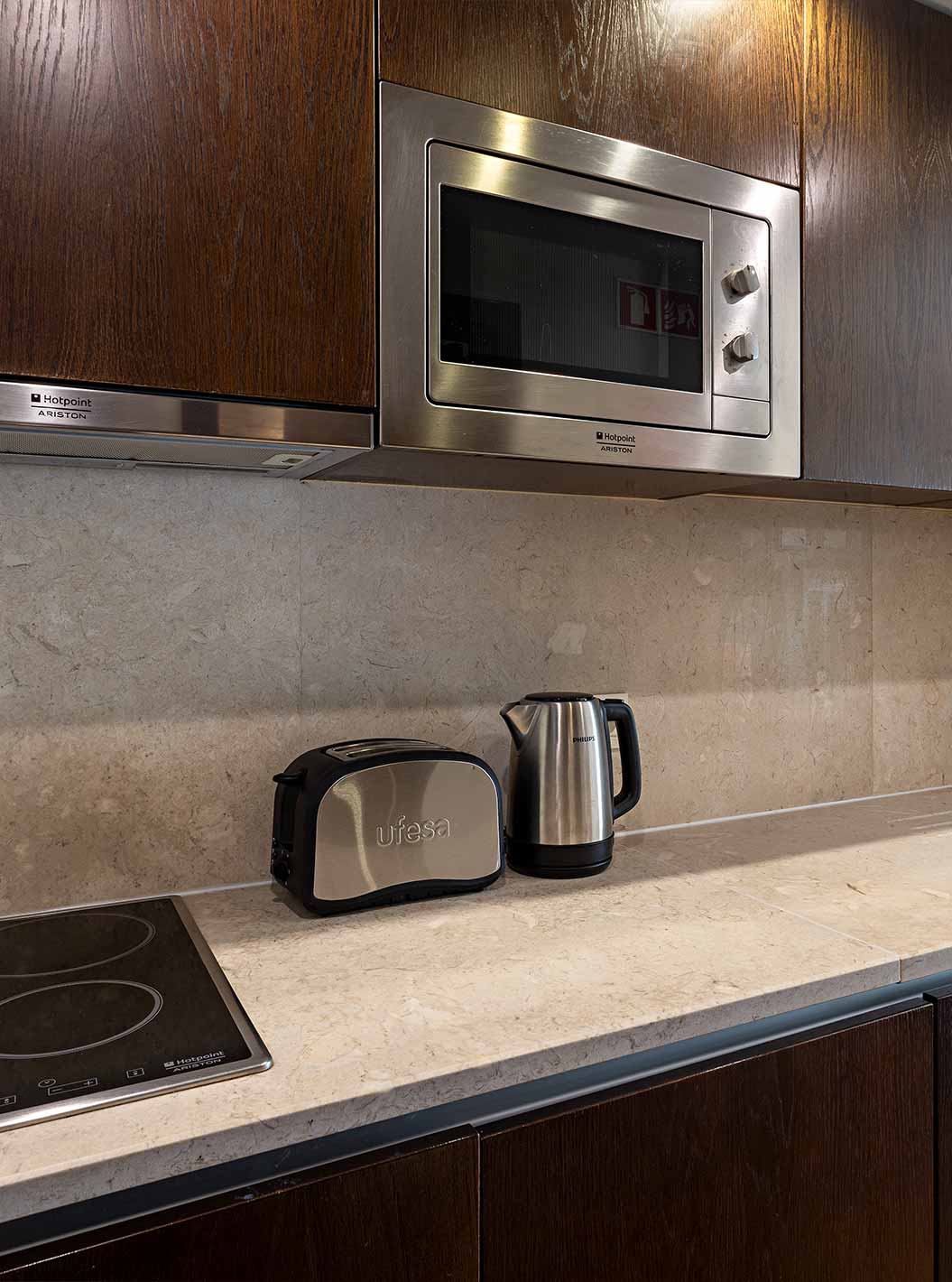 De Cliff Studio in Pestana Alvor Praia heeft een uitgeruste keuken in donker hout en steen, met fornuis en magnetron