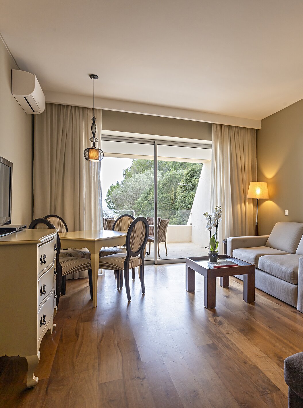 De Cliff Suite T1 in Pestana Alvor Praia heeft een woonkamer met 2 banken, een dressoir met tv, een eettafel en stoelen