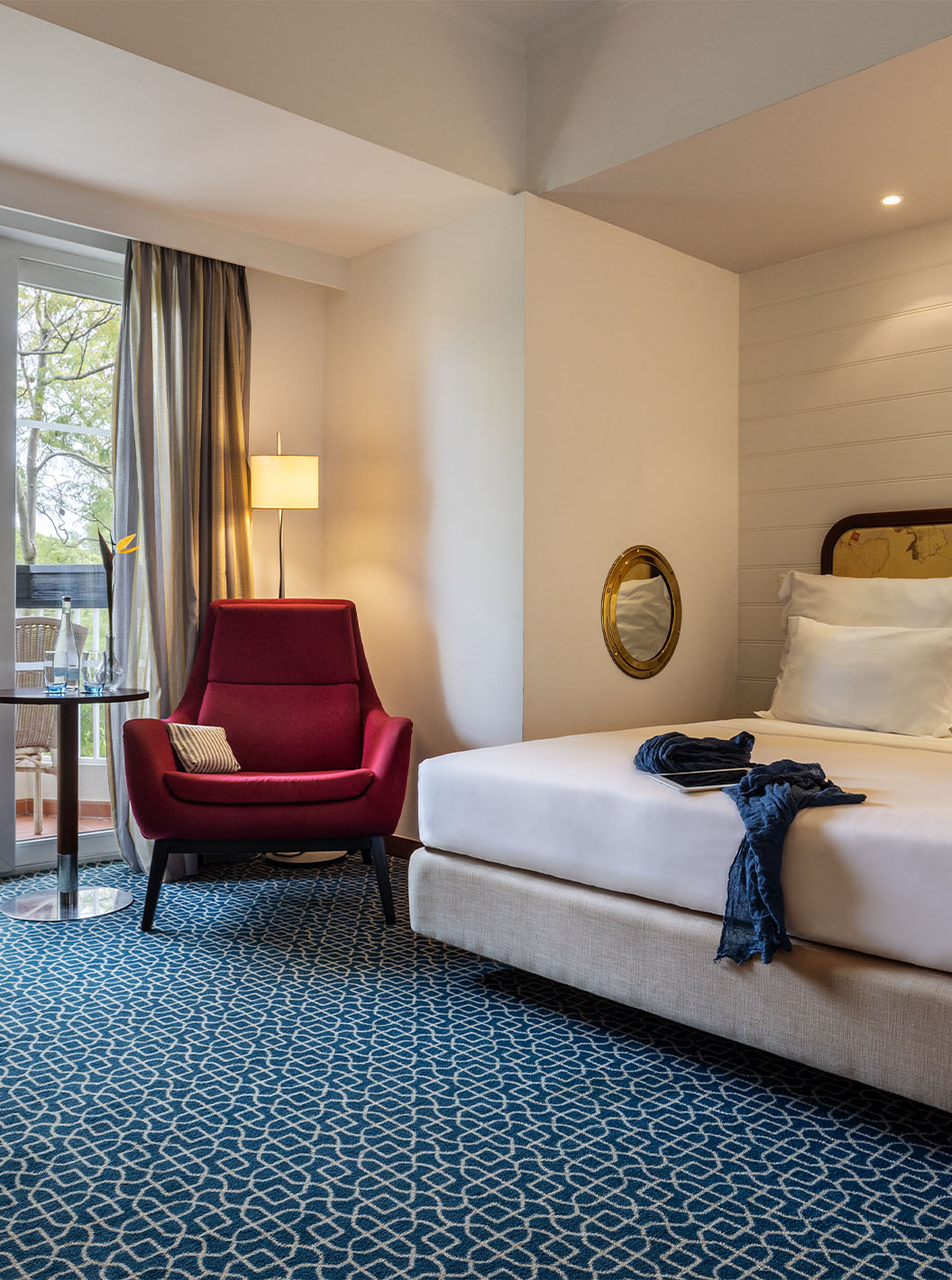 De Suite met uitzicht op de tuin van Pestana Alvor Praia heeft een tweepersoonsbed, rode fauteuil en balkon met uitzicht